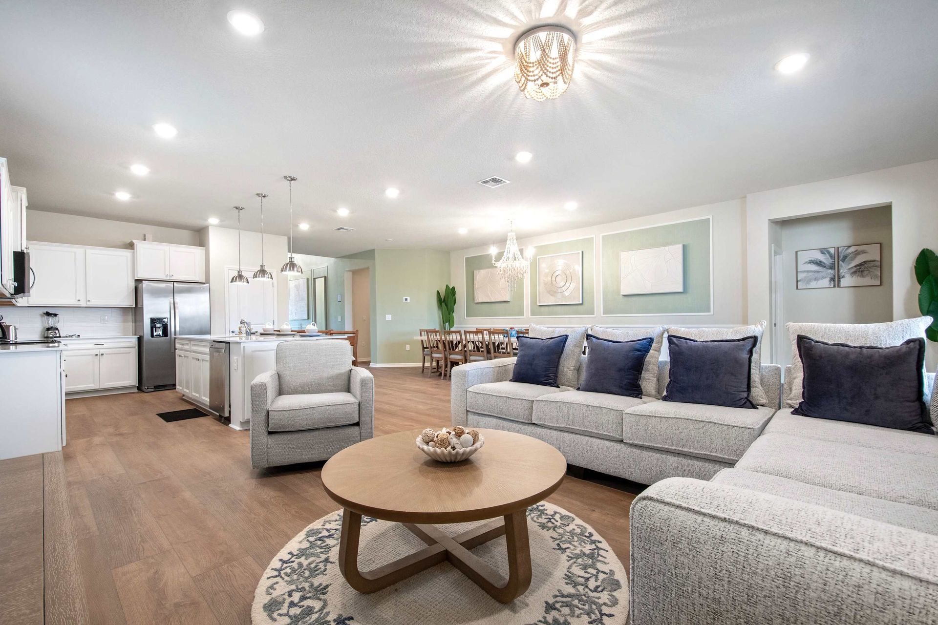Open-concept living with plush seating, full kitchen, and elegant dining space.
