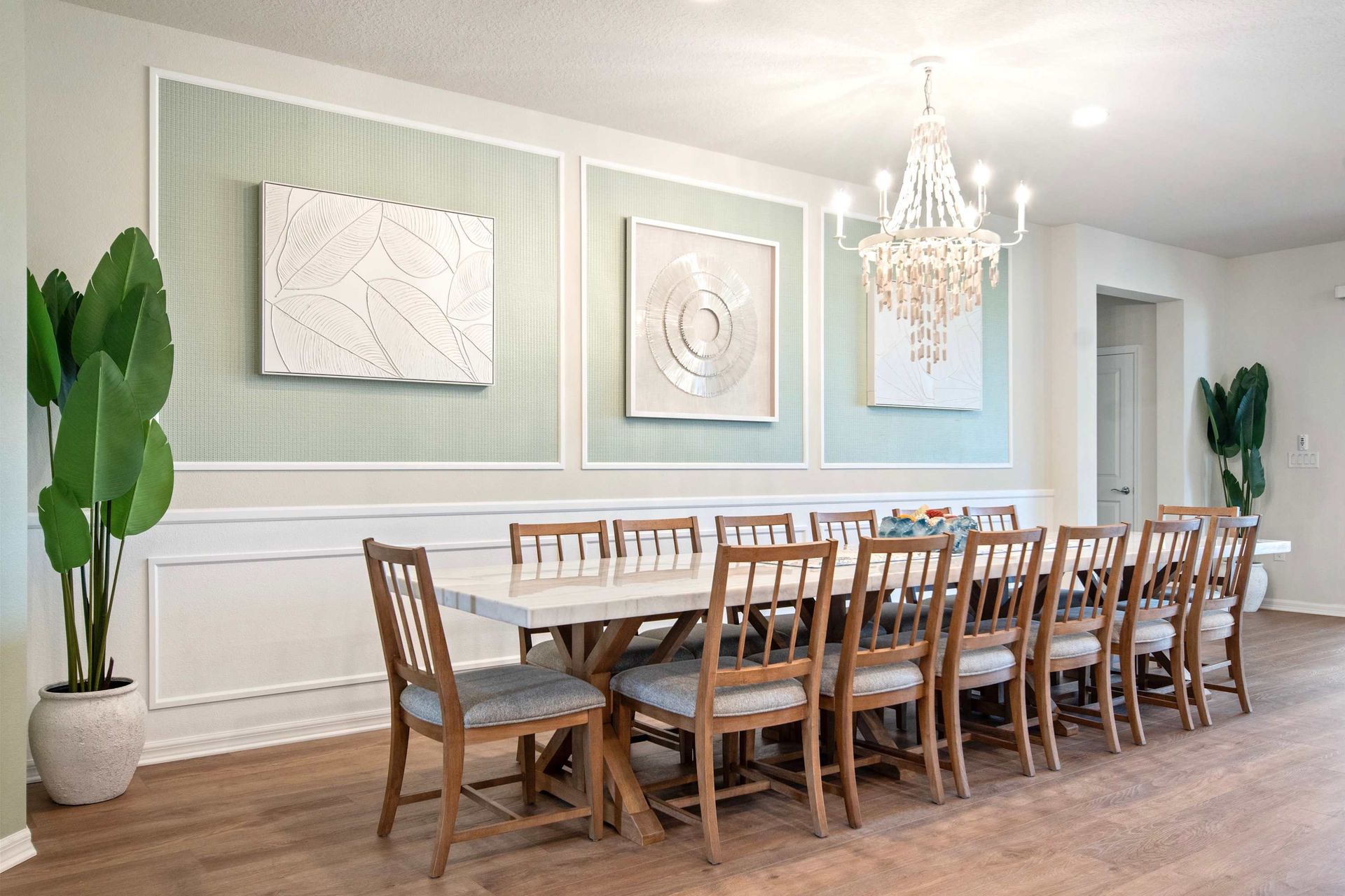 Elegant dining room with chandelier, seating for 12, and stylish wall art.
