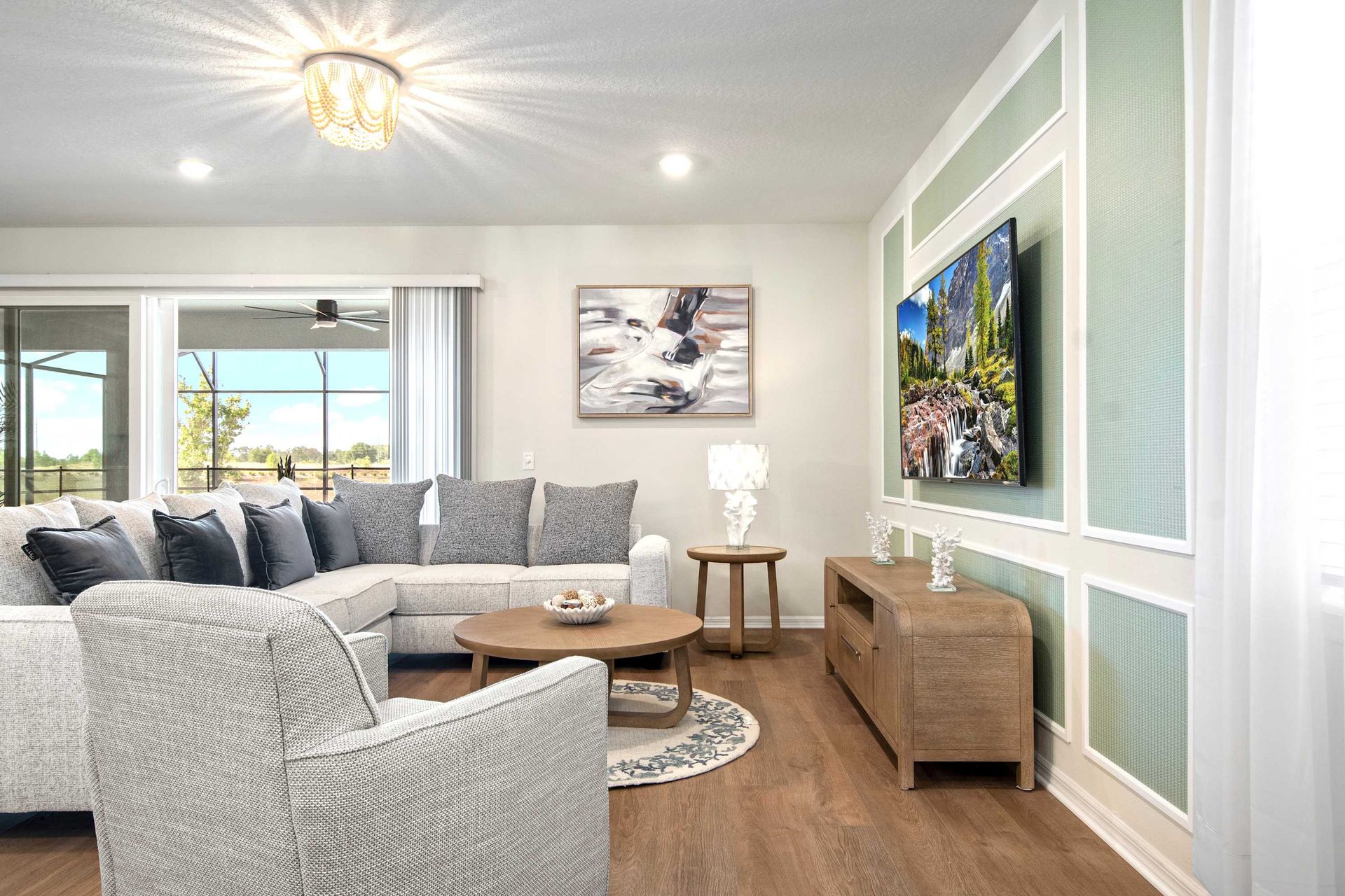 Bright, open living room with comfy seating, large TV, and patio access.
