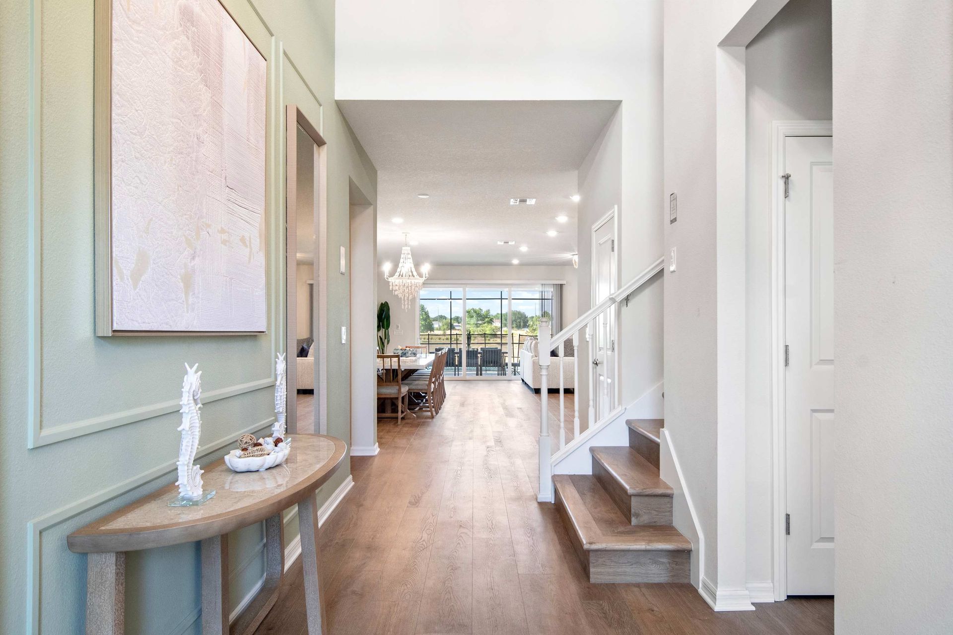 Bright, welcoming entryway with stylish décor, open sightlines, and elegant stairs.
