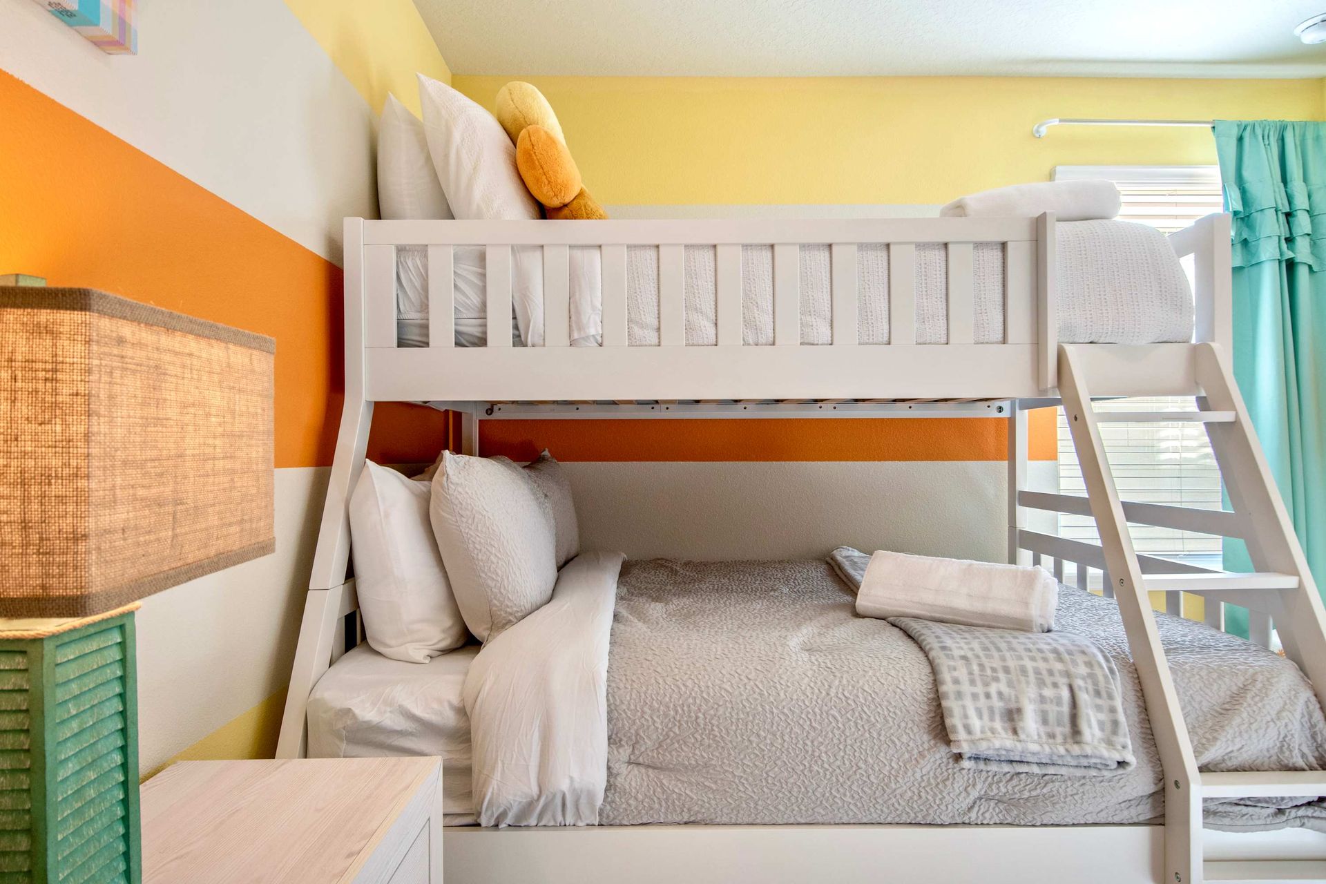 Colorful kids’ room with twin-over-full bunk bed, playful décor, and bright vibes.
