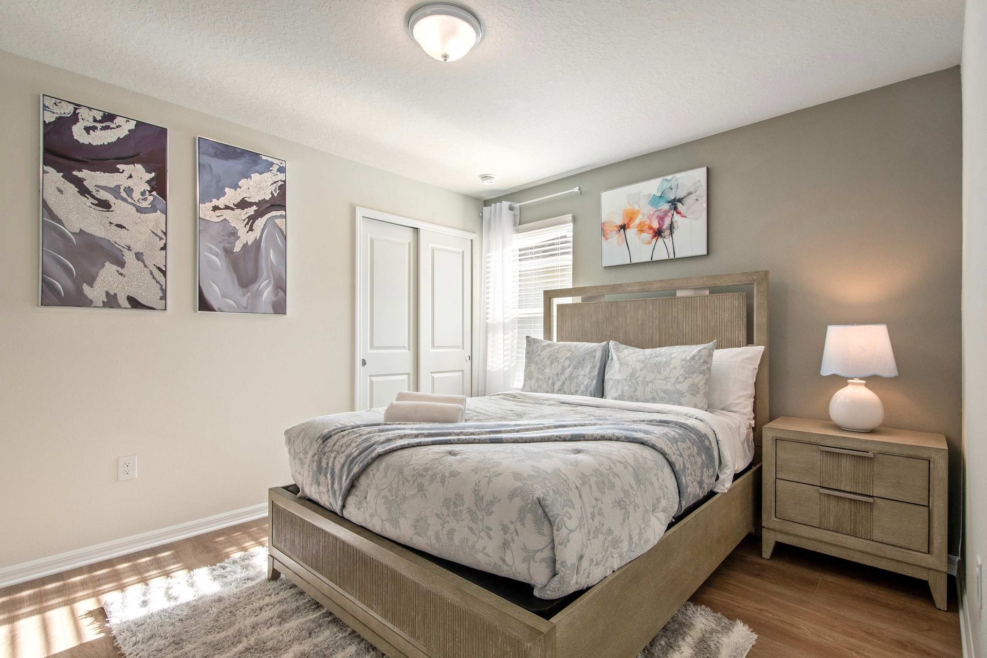 Peaceful queen bedroom with neutral tones, cozy bedding, and soft natural light.
