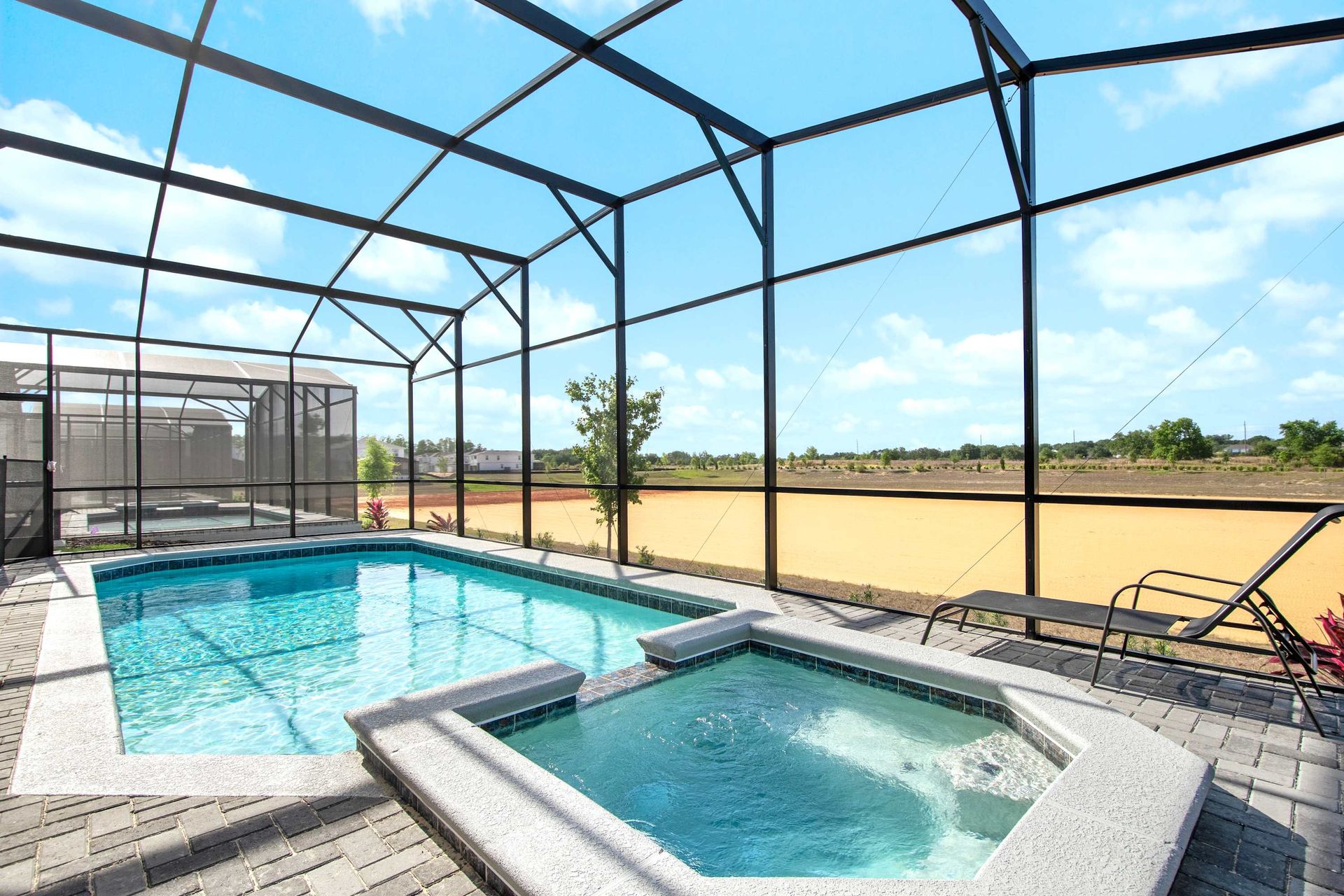 Private screened pool and spa with loungers, sunny views, and total relaxation.

