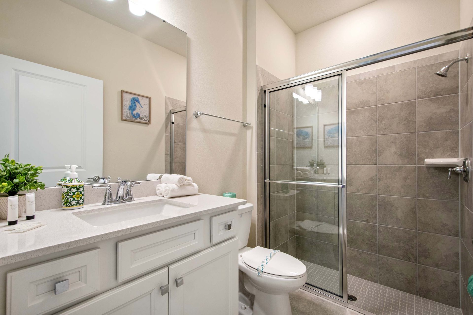 Sleek full bathroom with glass shower, modern fixtures, and bright clean design.
