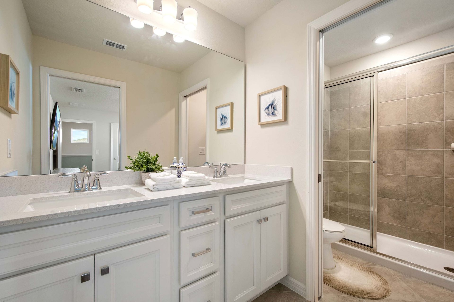 Sleek full bathroom with glass shower, modern fixtures, and bright clean design.