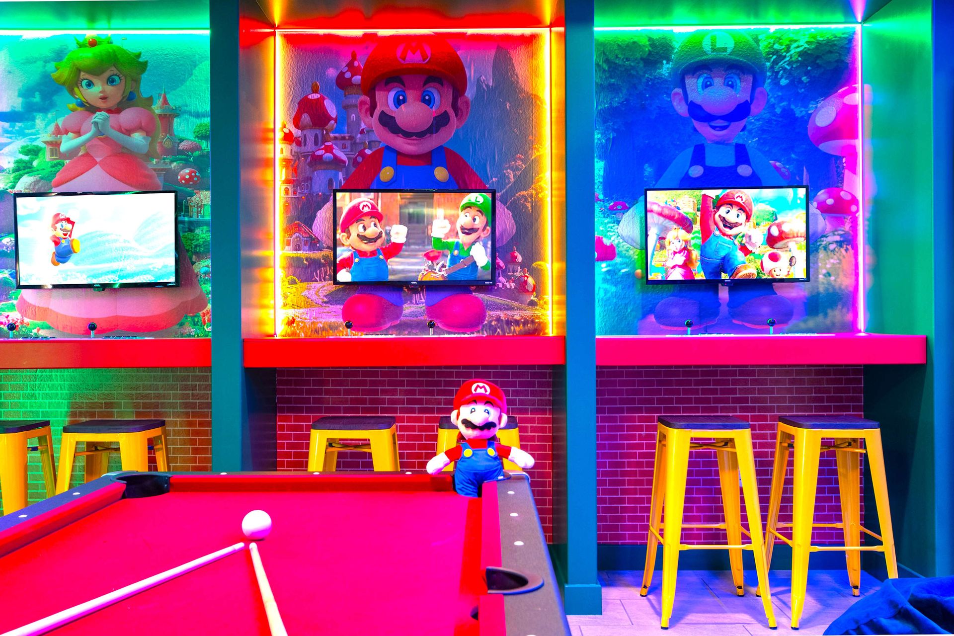 Colorful Super Mario arcade zone with gaming stations, pool table, and wall art!
