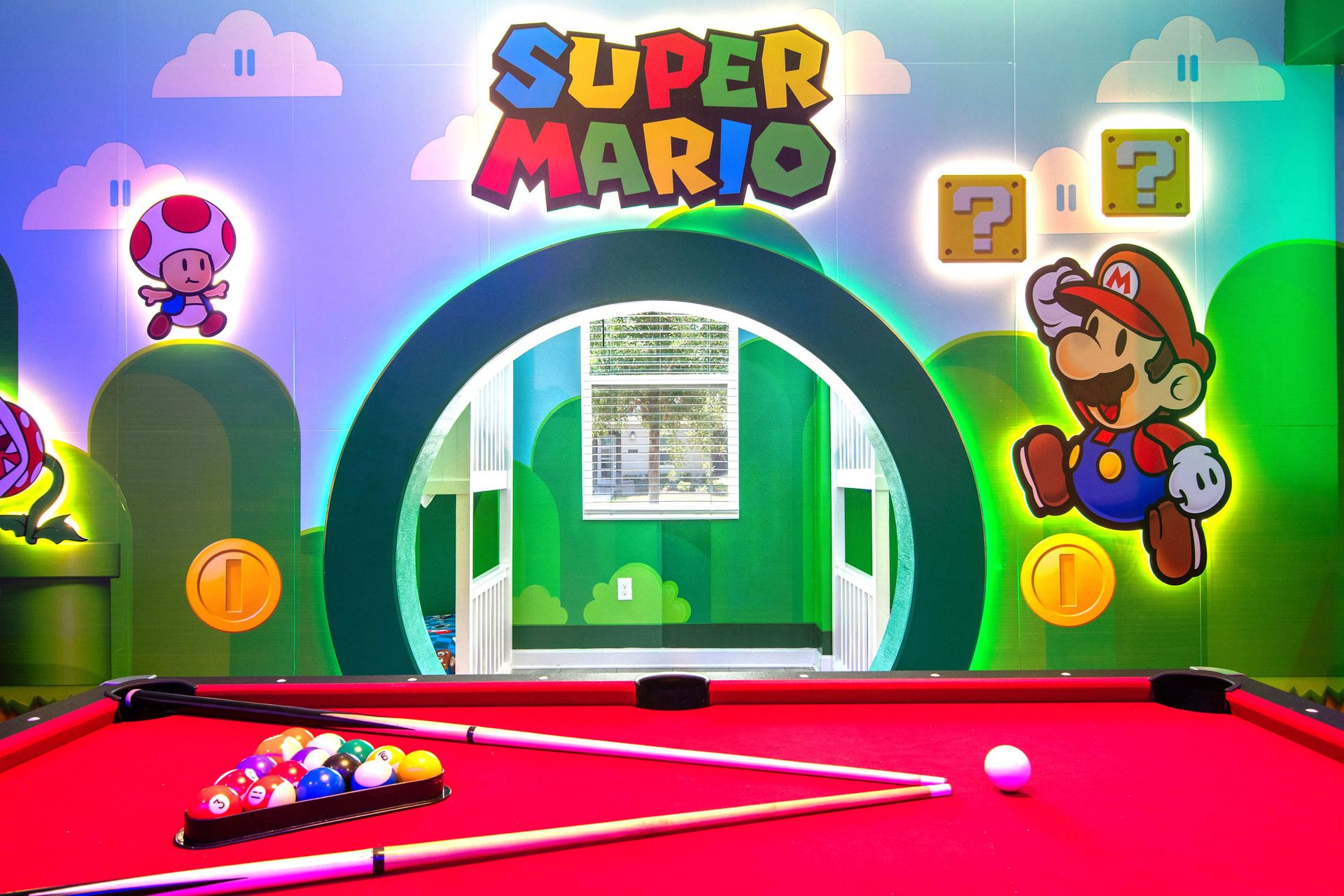 Super Mario game room with pool table, vibrant murals, and arcade-style fun!

