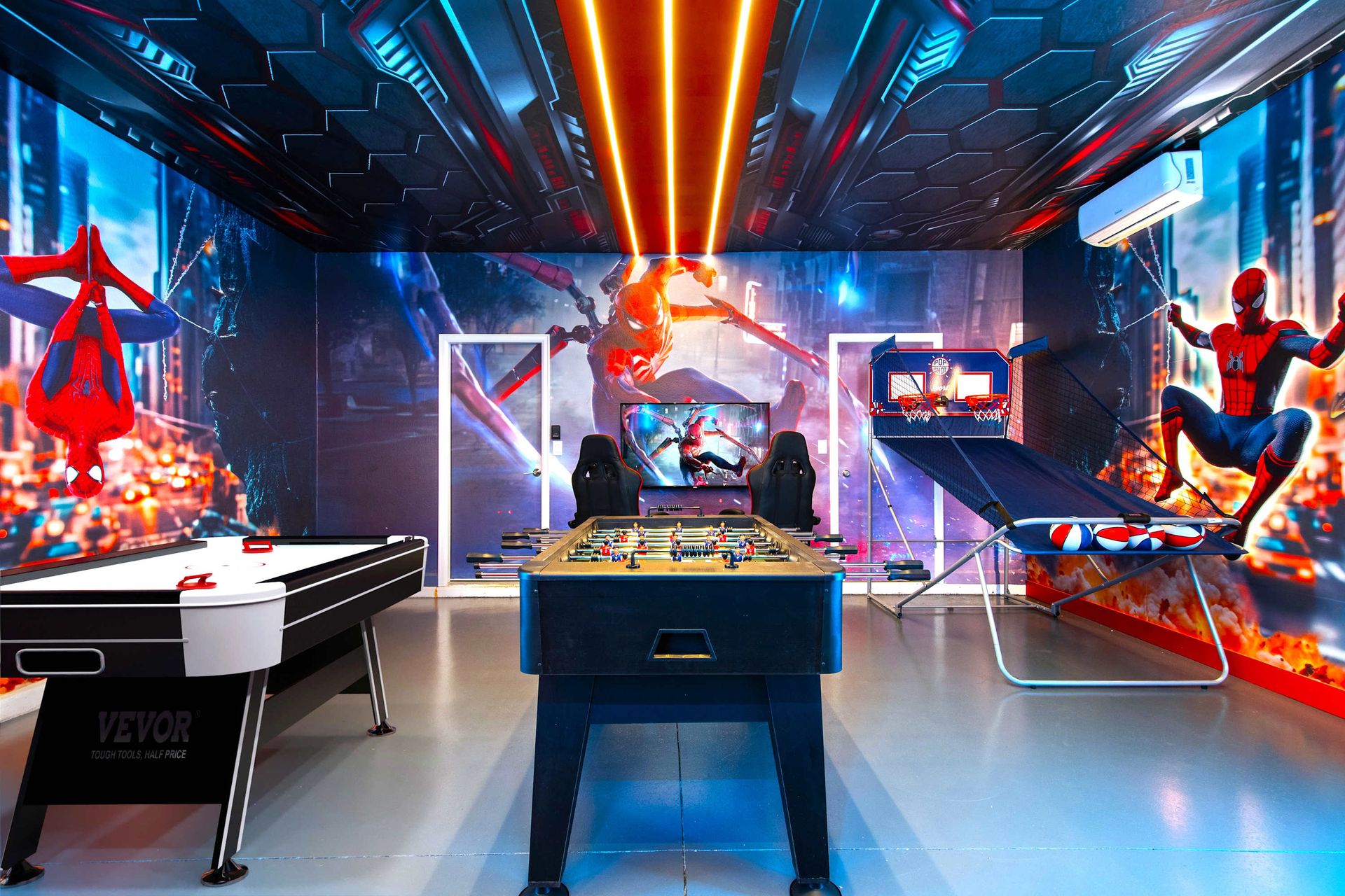 Ultimate Spider-Man game room with foosball, gaming chairs, and bold decor.
