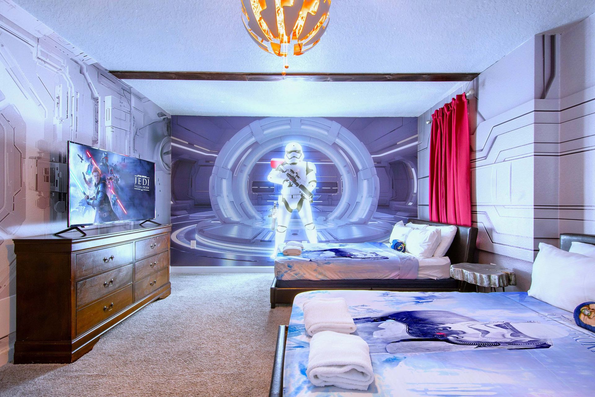 Futuristic space-themed bedroom with 3 beds, glowing wall art, and cozy vibes.
