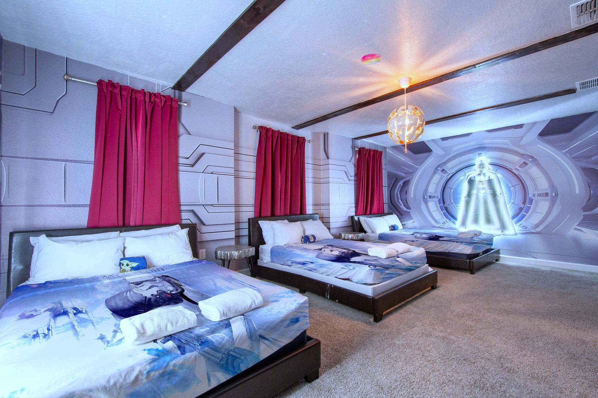 Futuristic space-themed bedroom with 3 beds, glowing wall art, and cozy vibes.
