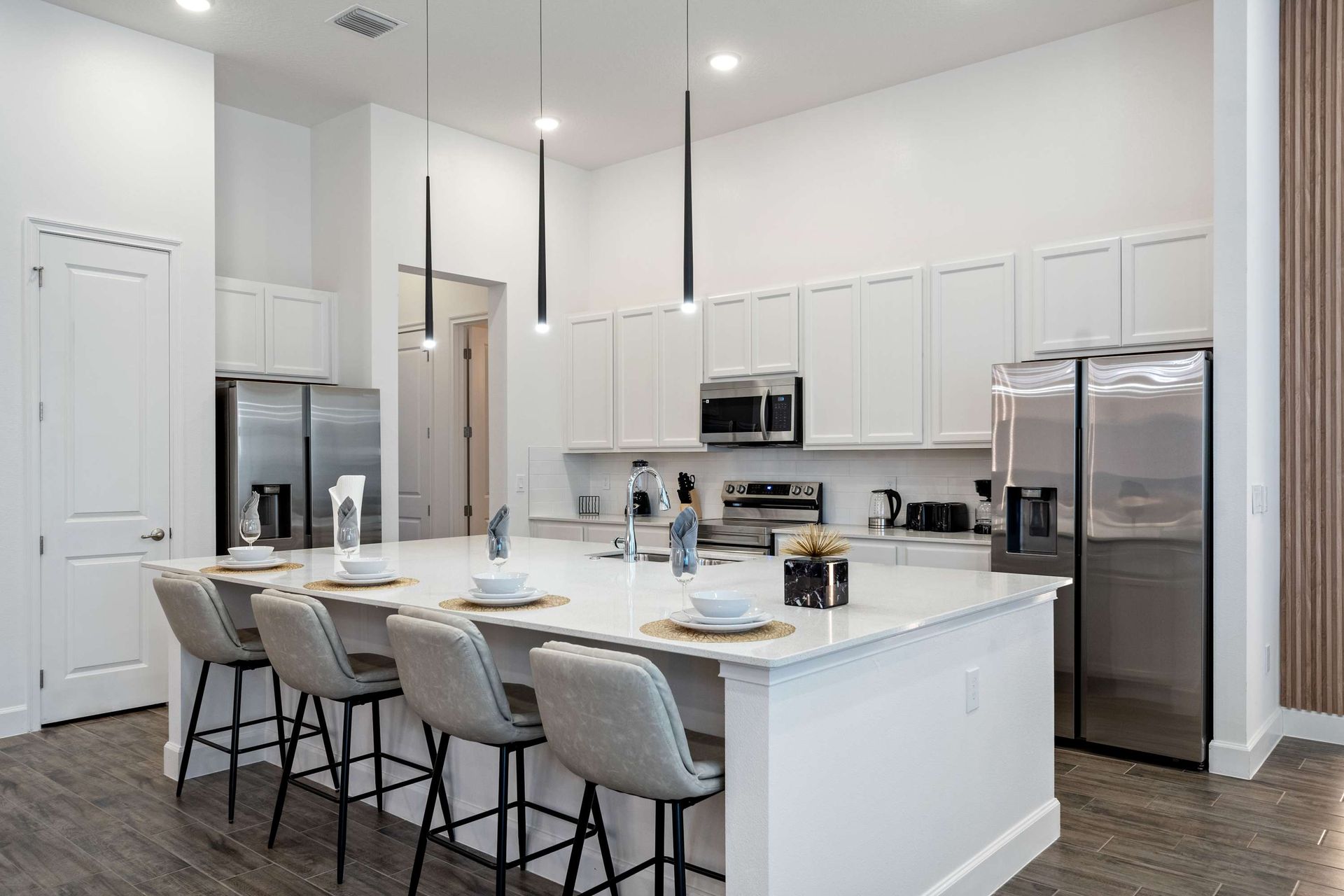 Sleek chef’s kitchen with stainless steel appliances and a spacious island bar
