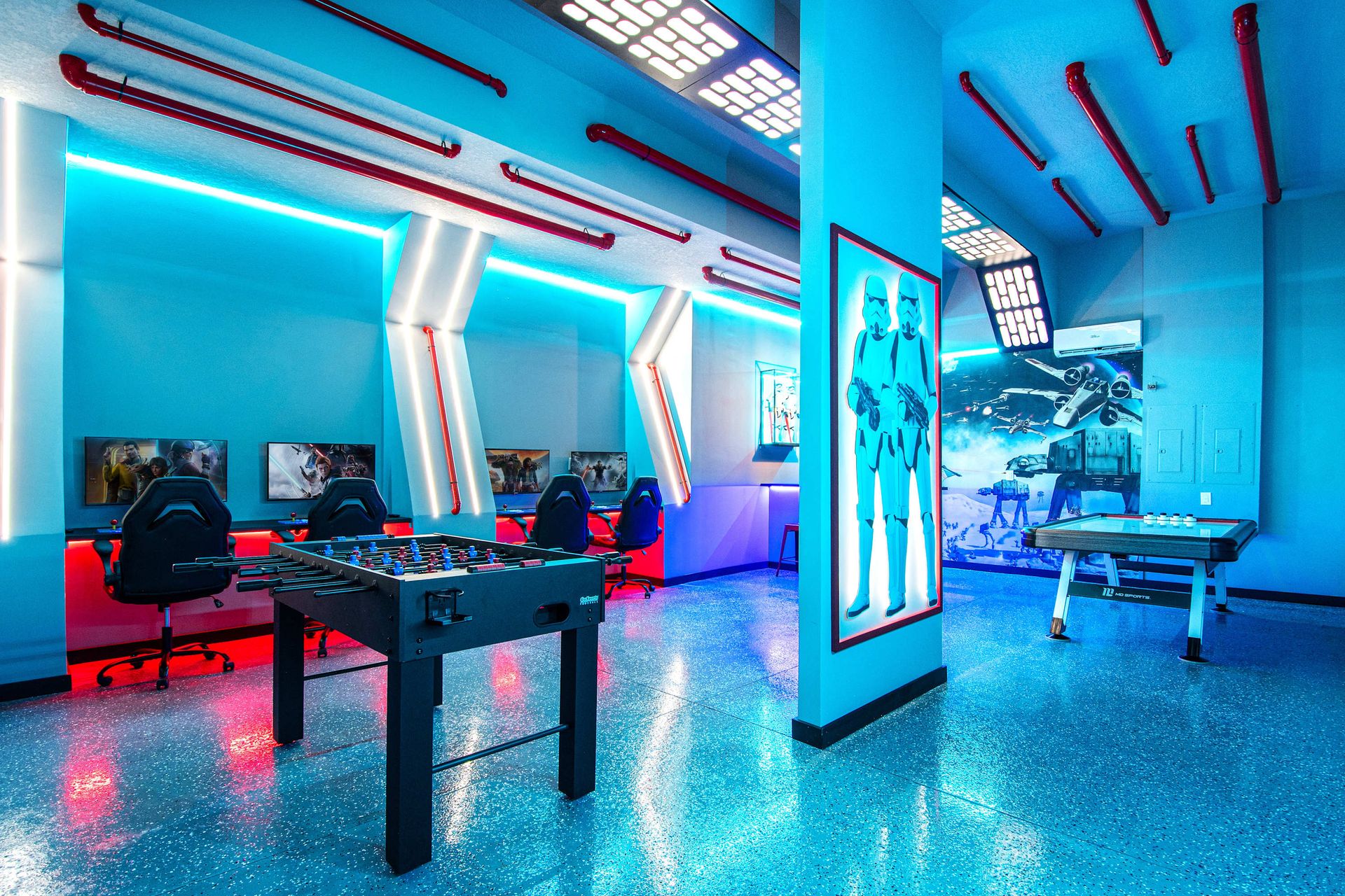 Futuristic gaming lounge with neon lights, foosball, and immersive sci-fi decor.
