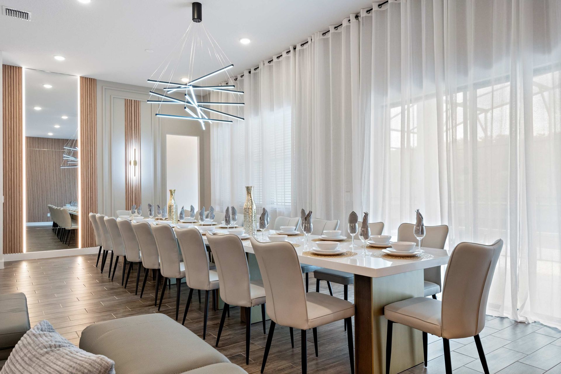 Elegant dining space with seating for 16, modern lighting, and natural light
