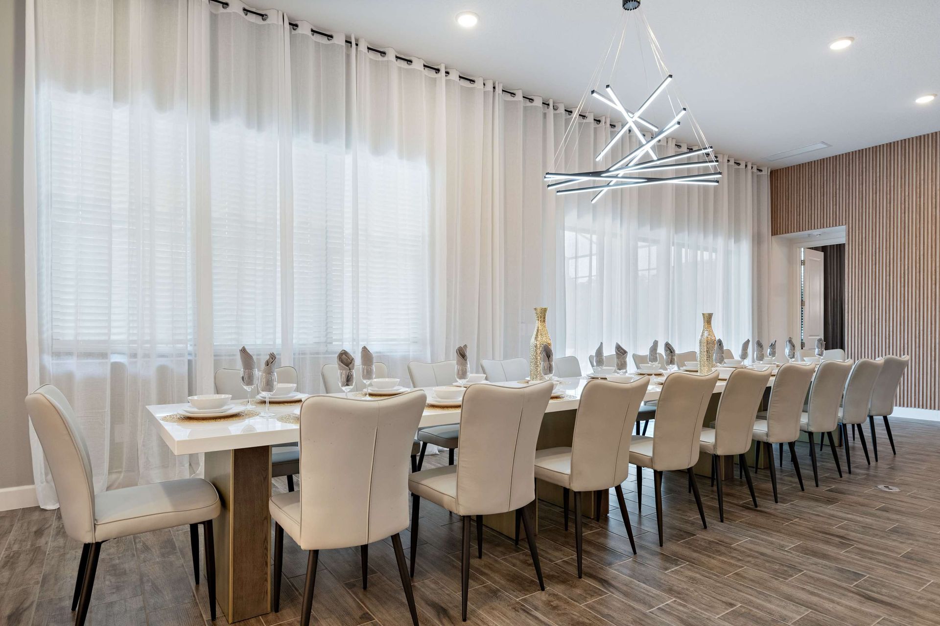 Elegant dining space with seating for 16, modern lighting, and natural light
