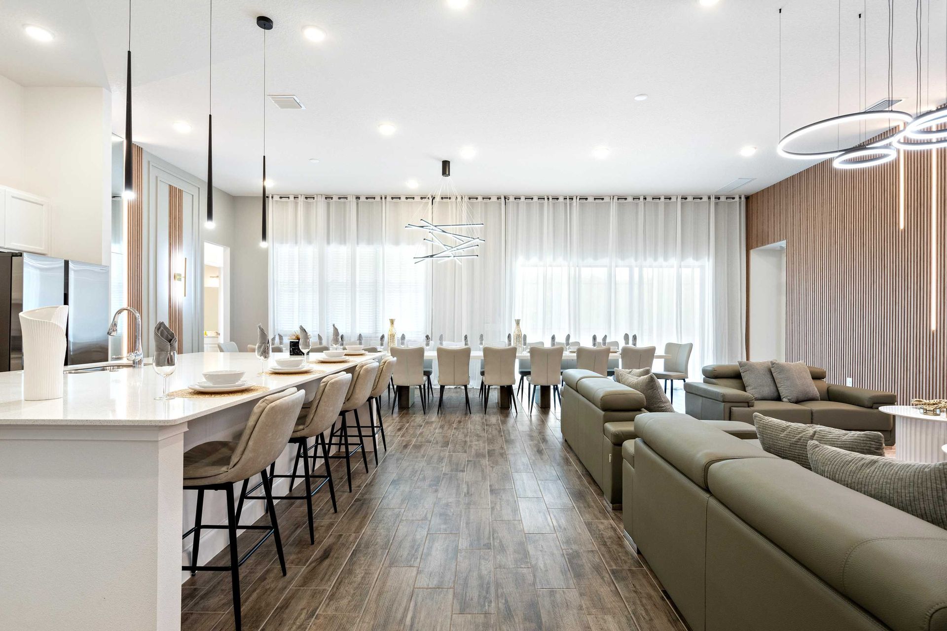 Expansive open layout with gourmet kitchen, long dining table, and plush seating
