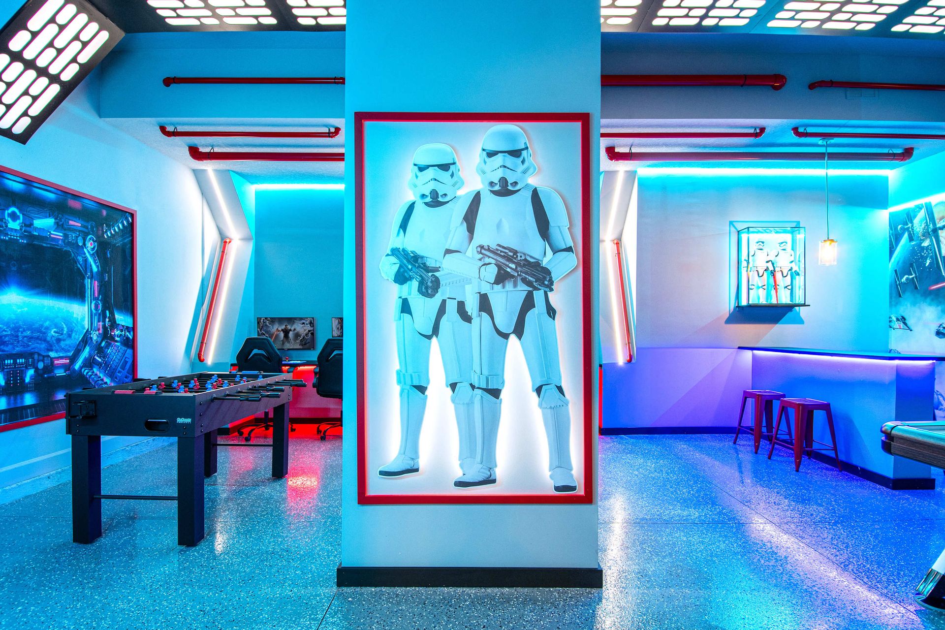 Galactic-themed game room with foosball, neon lighting, and epic sci-fi decor
