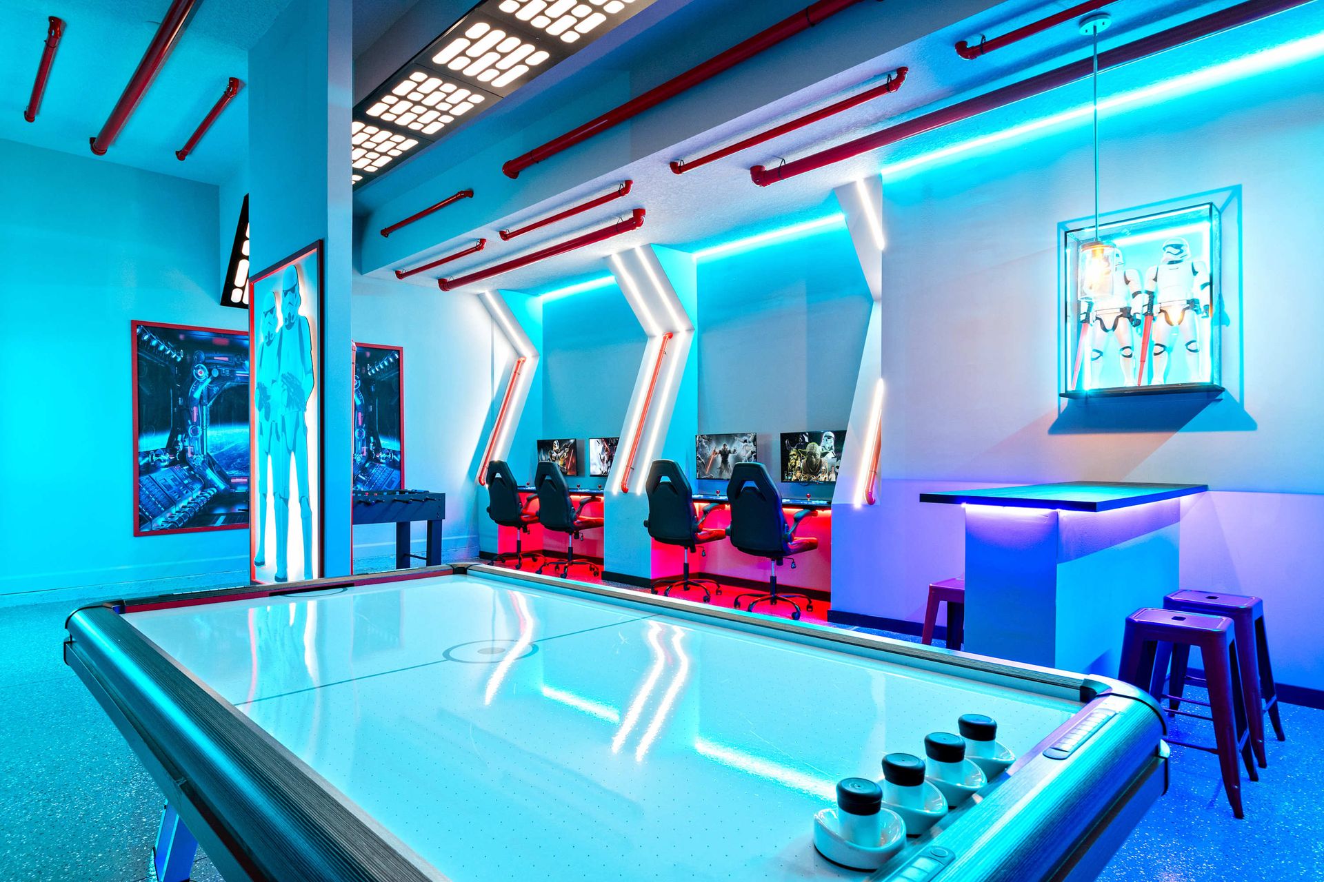 Immersive sci-fi arcade with air hockey, gaming PCs, and glowing neon accents
