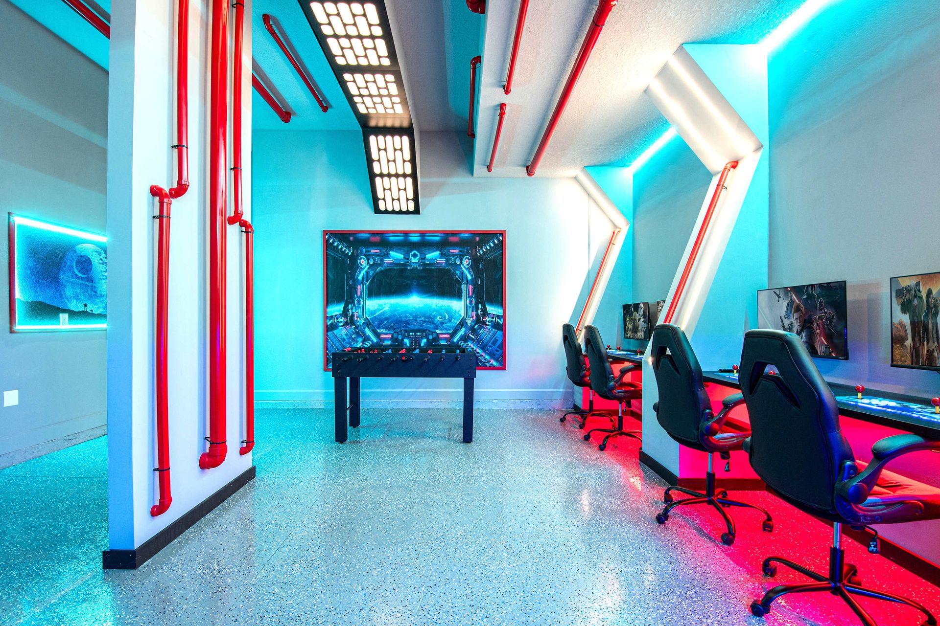 Futuristic game zone with foosball, gaming stations, and bold neon lighting
