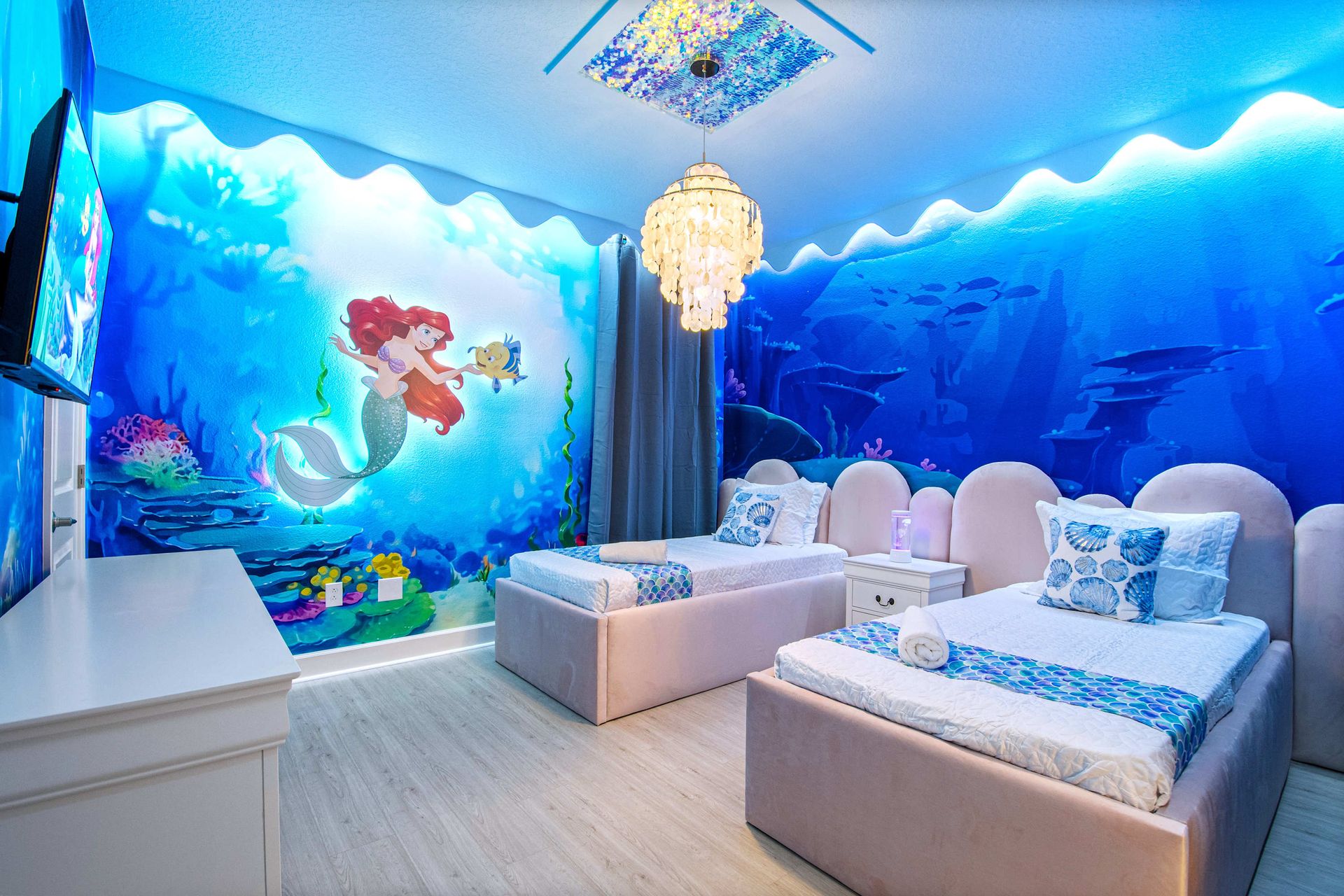 Underwater-themed bedroom with mermaid mural, soft lighting, and whimsical charm

