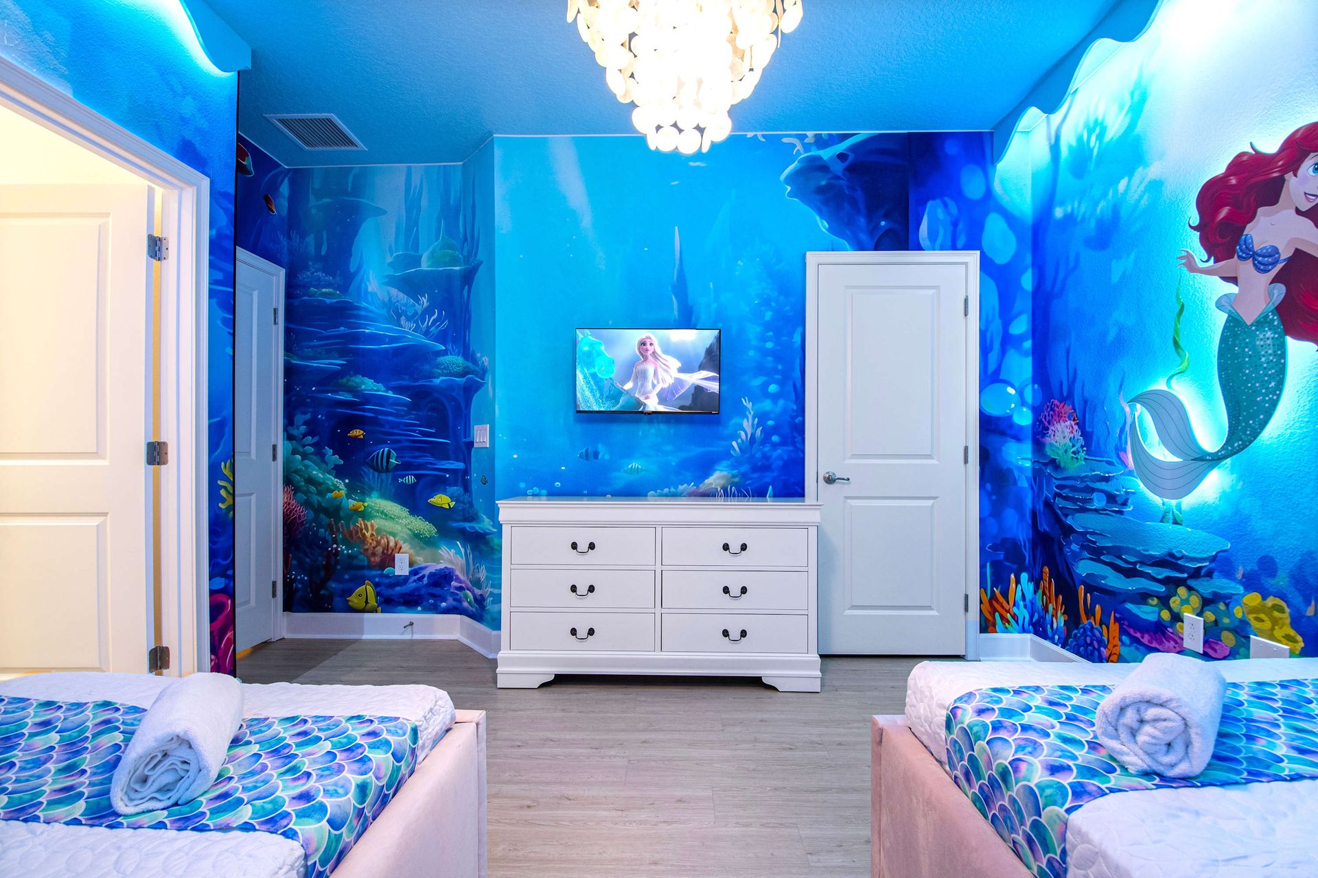 Underwater-themed bedroom with mermaid mural, soft lighting, and whimsical charm
