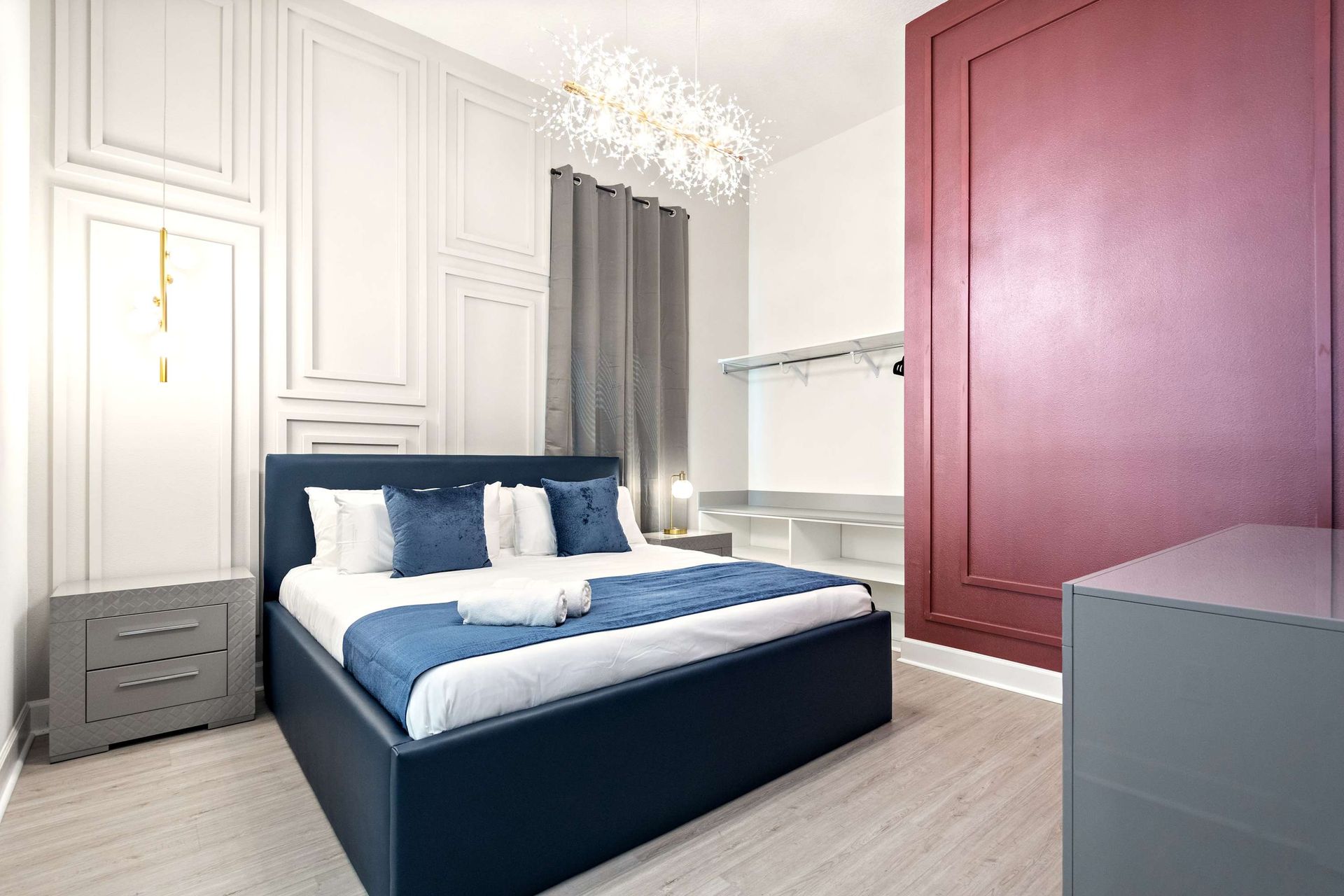 Stylish bedroom with bold accents, crystal chandelier, and luxurious king bed
