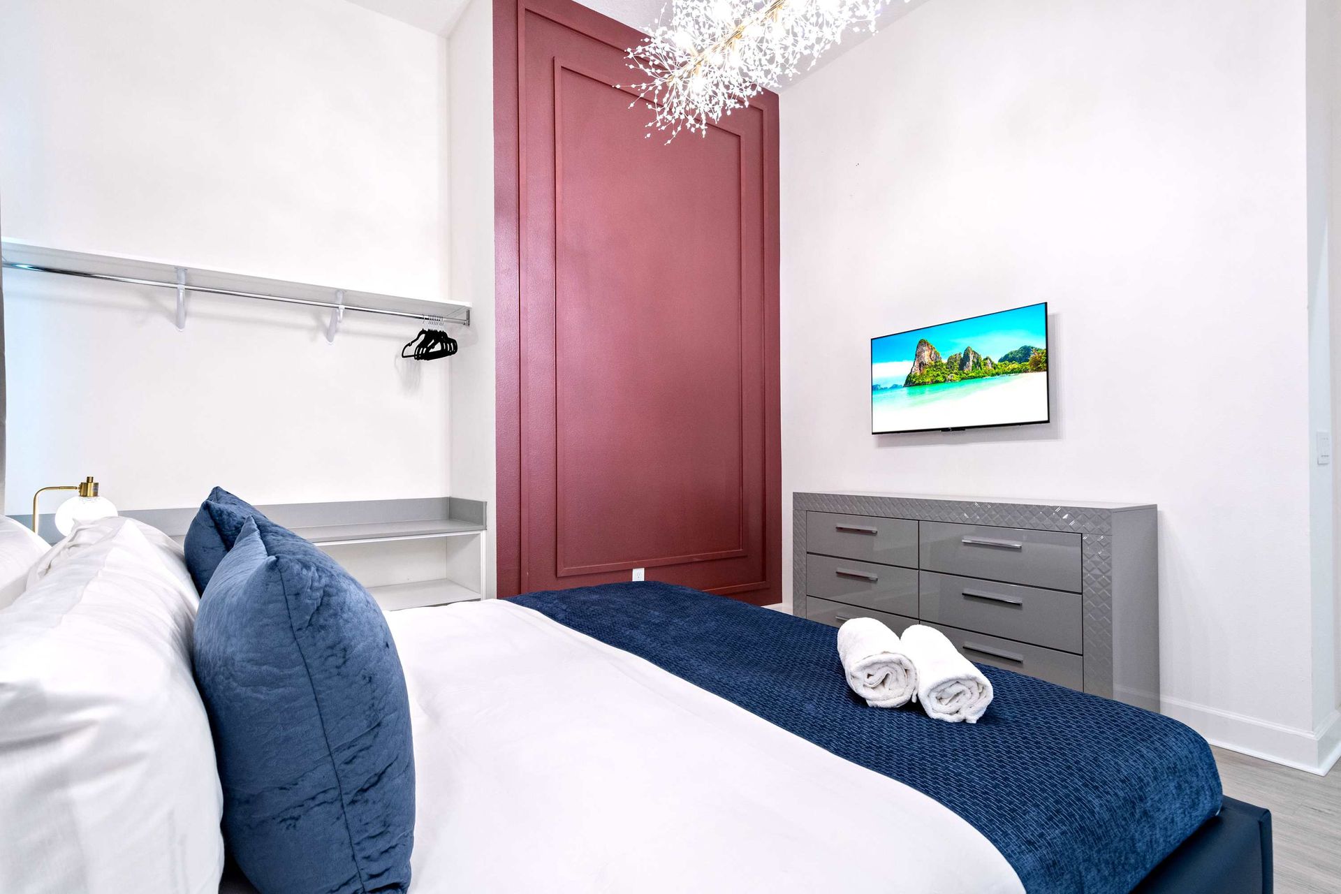 Stylish bedroom with bold accents, crystal chandelier, and luxurious king bed
