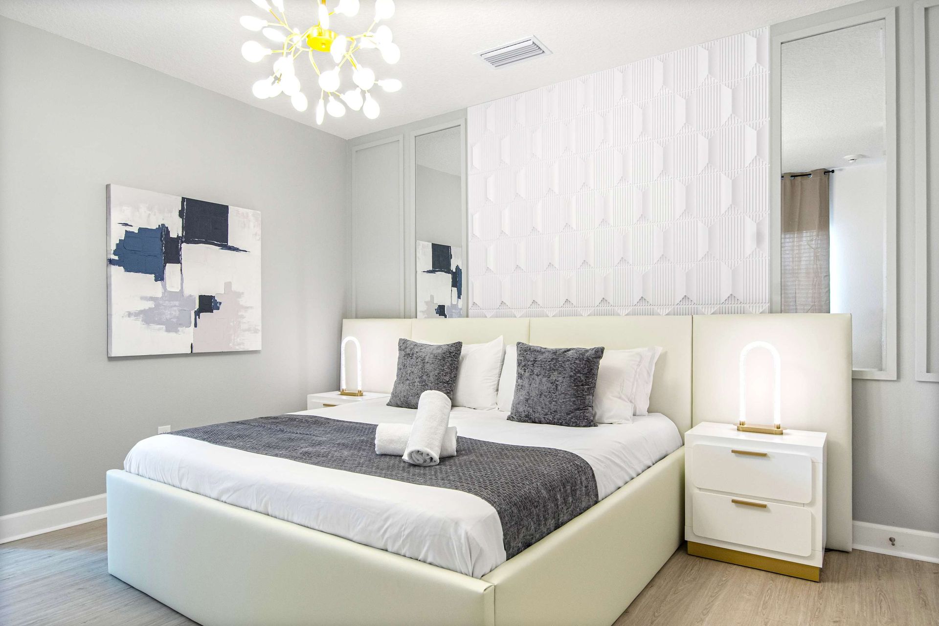 Bright and modern bedroom with textured accent wall, cozy king bed, and chic decor
