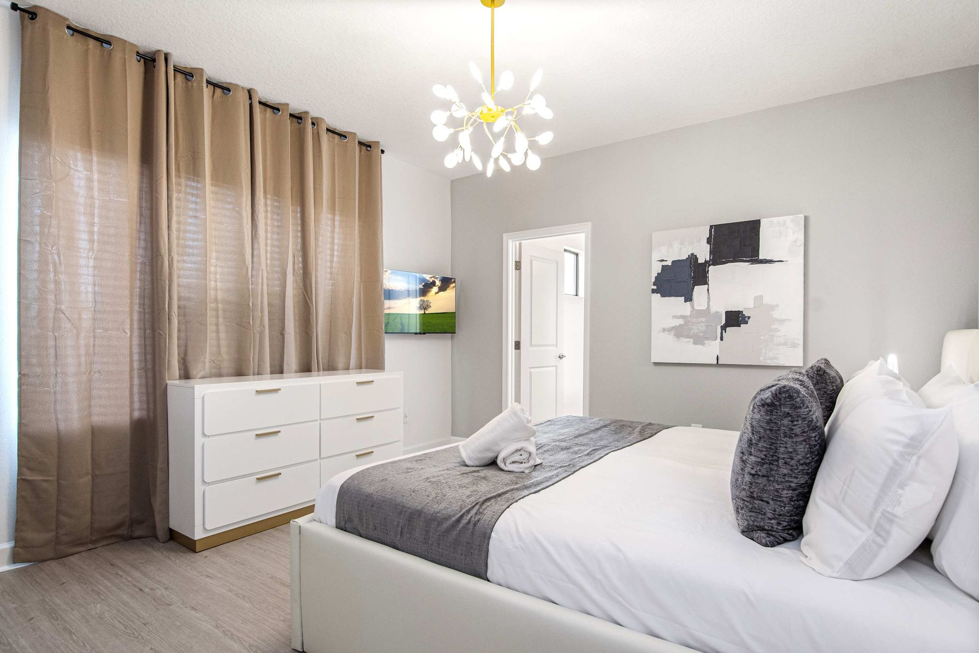 Bright and modern bedroom with textured accent wall, cozy king bed, and chic decor
