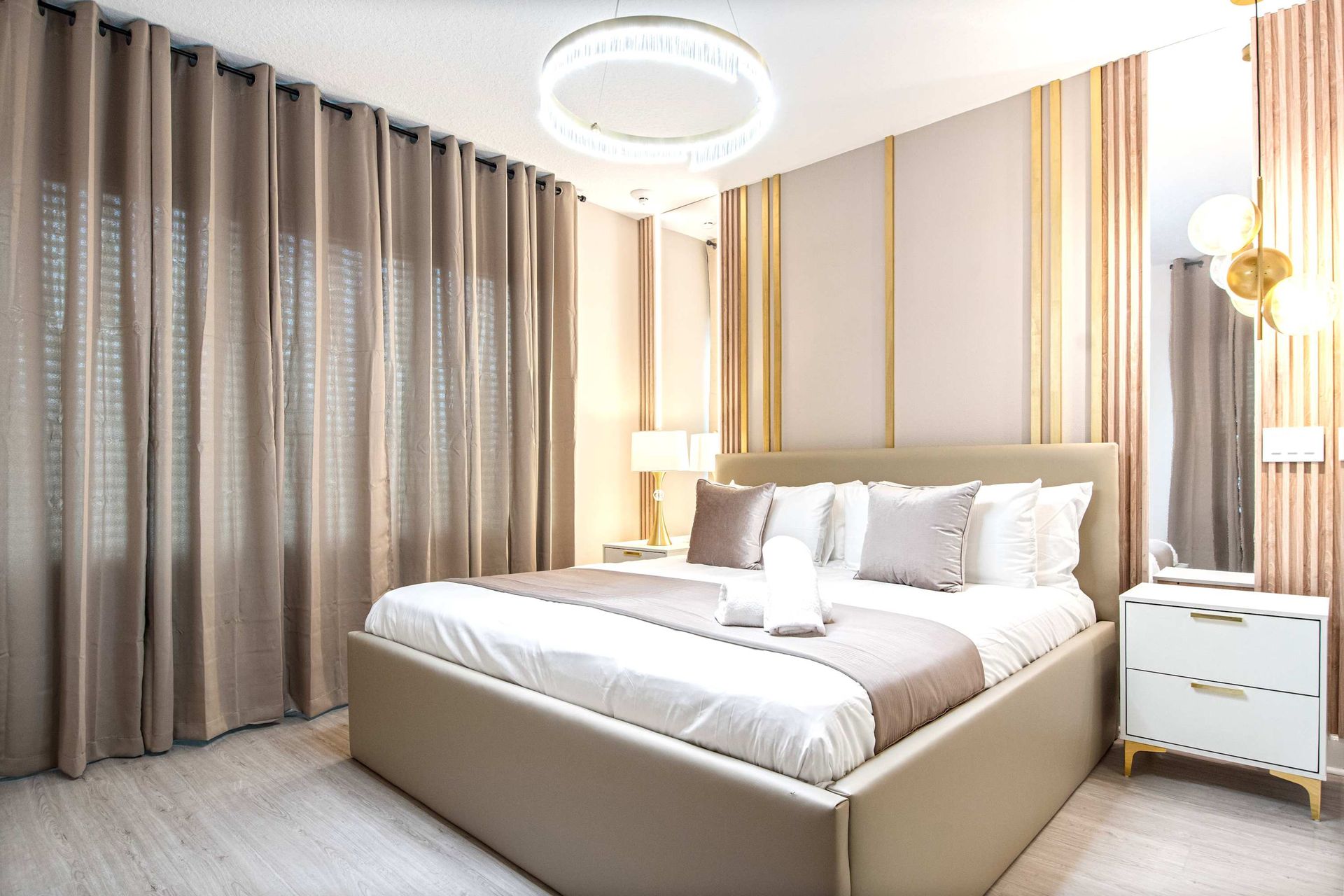 Luxurious bedroom with gold accents, plush bedding, and elegant draped curtains
