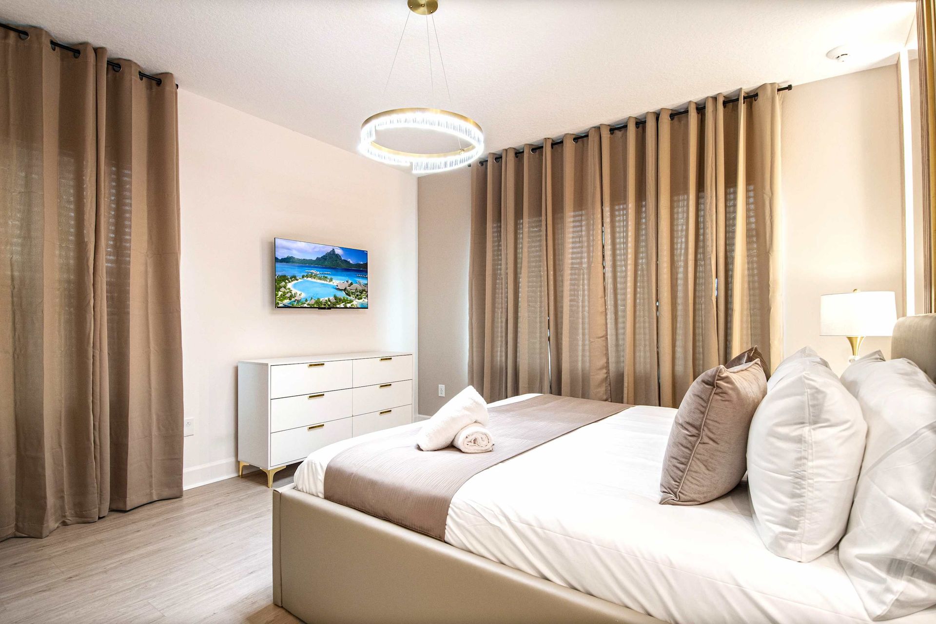 Serene and stylish bedroom with soft tones, modern lighting, and a cozy king bed
