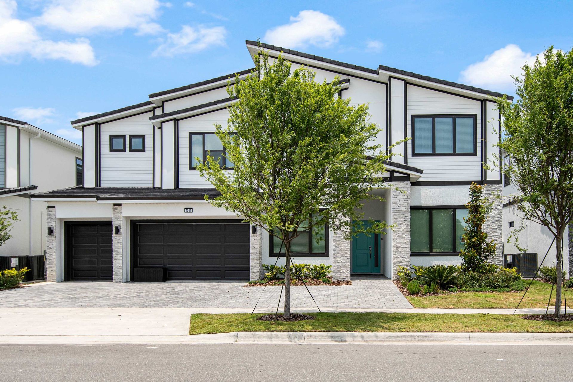 Modern luxury villa with sleek design, two-car garage, and beautifully landscaped entry
