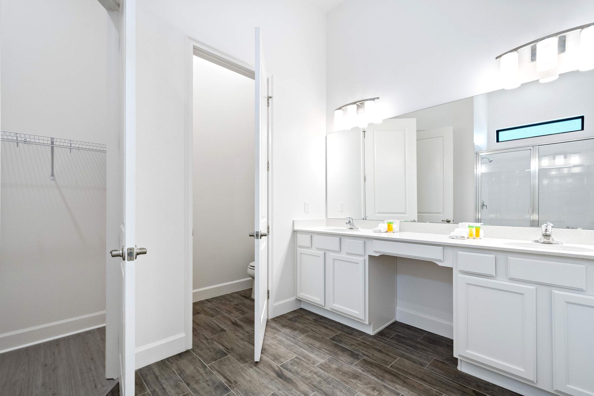 Spacious ensuite bath with double vanities, walk-in closet, and modern finishes
