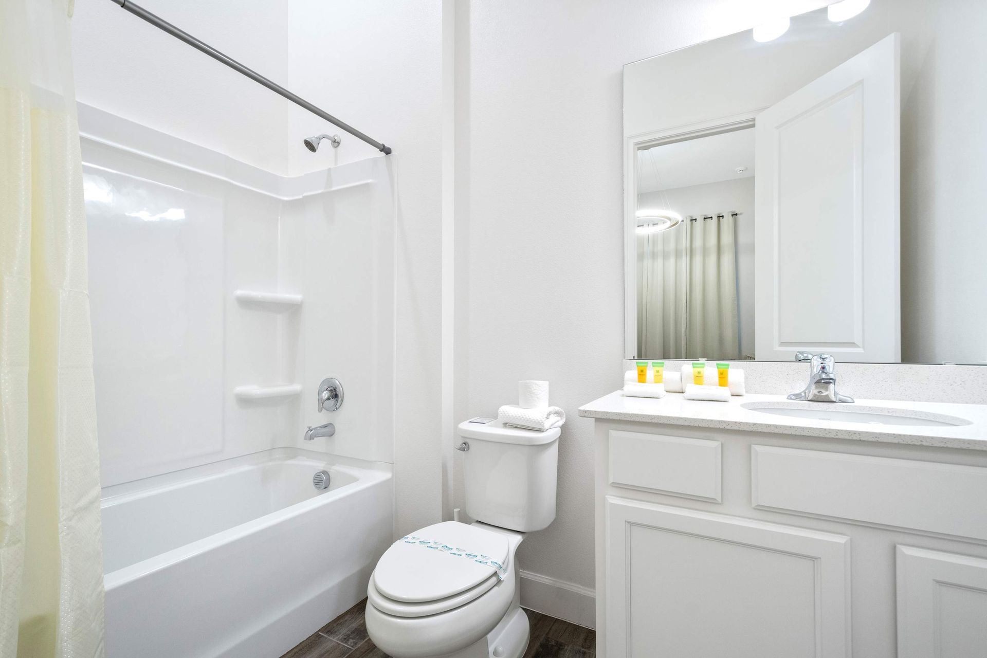 Modern full bathroom with bright white finishes, tub-shower combo, and essentials

