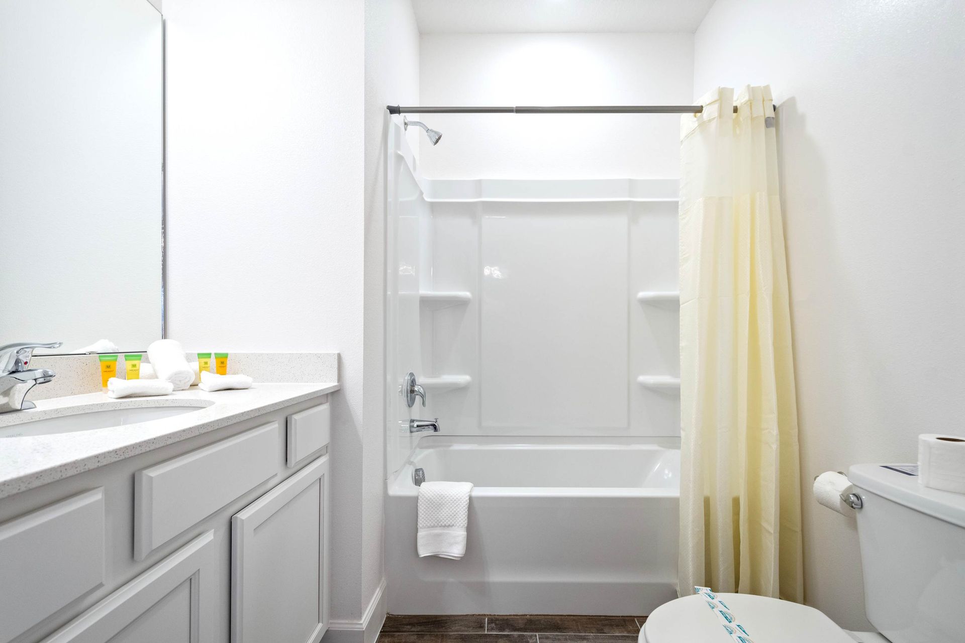 Bright, modern bathroom with sleek vanity, full tub-shower combo, and soft lighting
