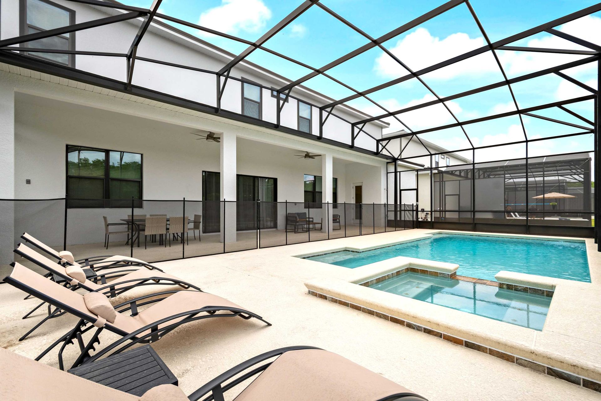 Screened-in pool and spa with serene lake views and comfortable lounge seating
