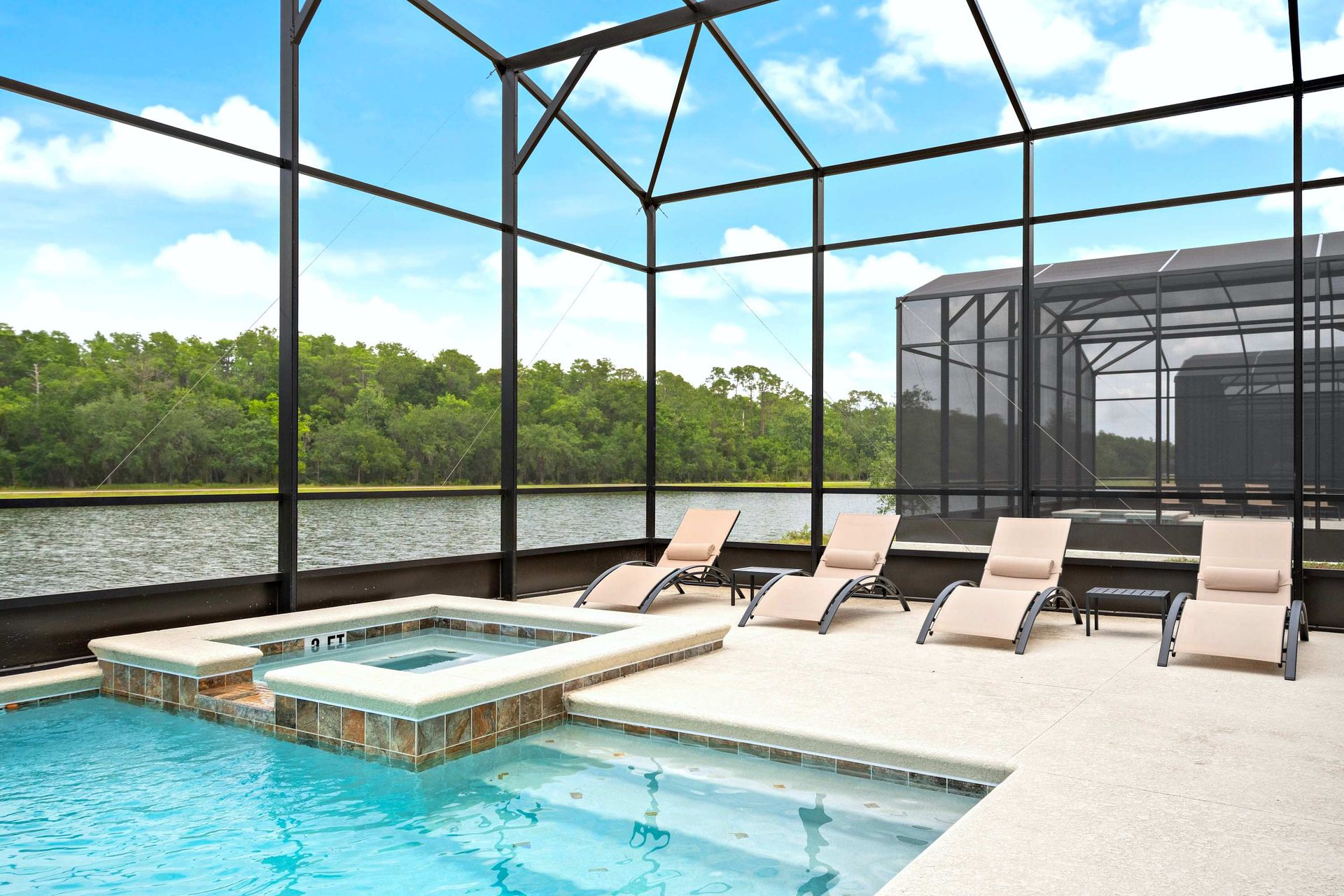 Screened-in pool and spa with serene lake views and comfortable lounge seating
