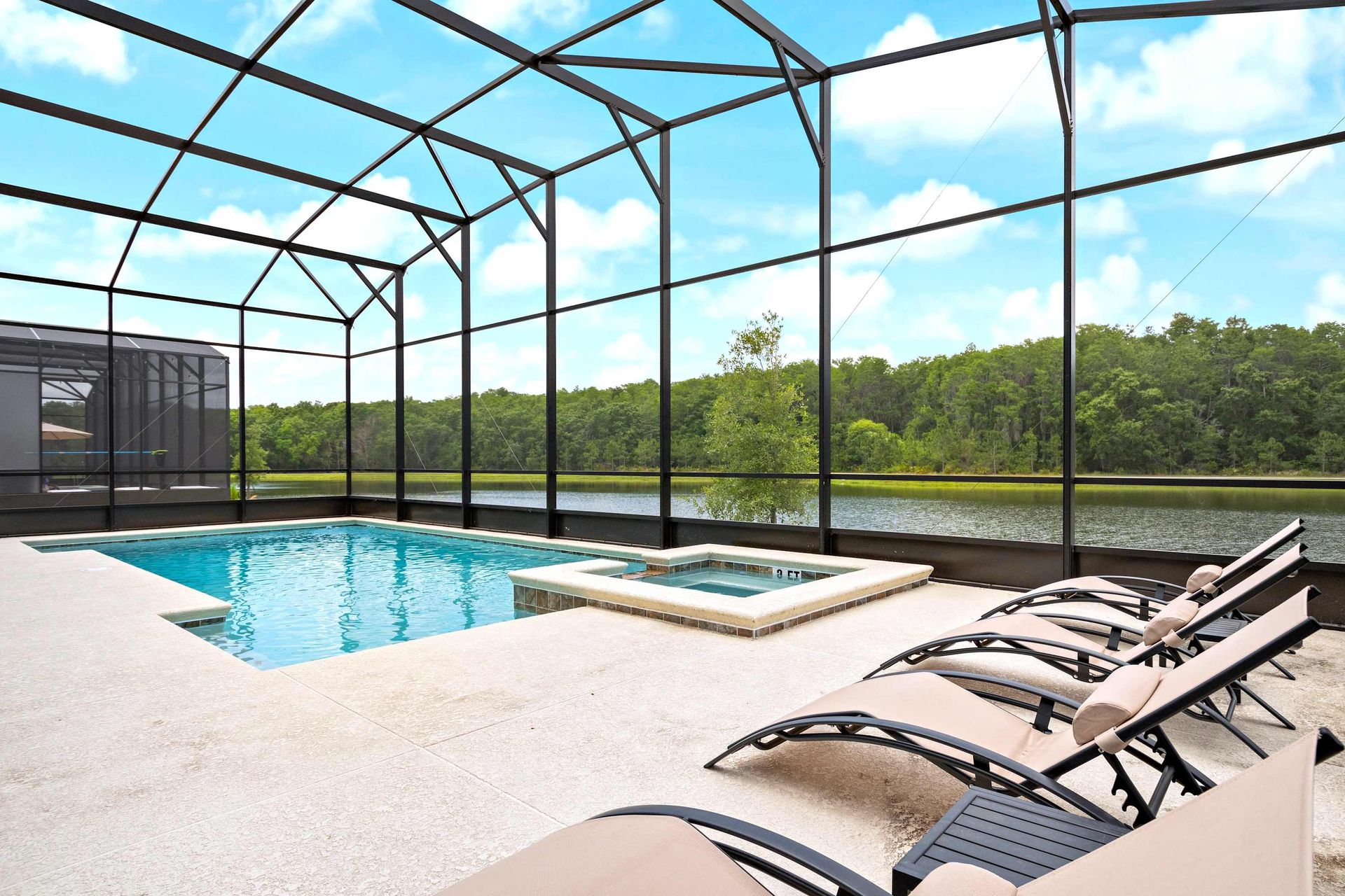 Screened-in pool and spa with serene lake views and comfortable lounge seating
