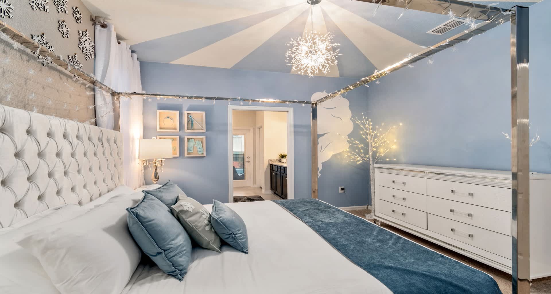 Chic blue and white bedroom with canopy bed, fairy lights, and dreamy snowflake decor!
