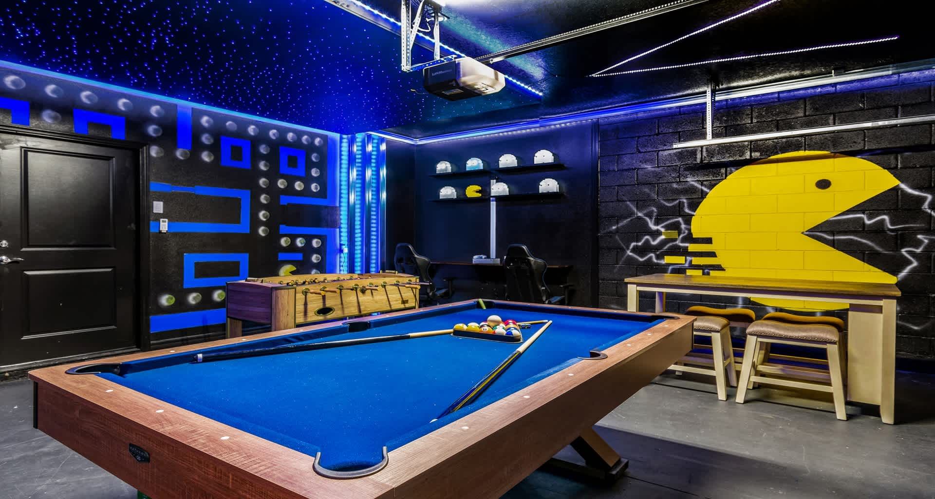 Retro arcade room with pool table, neon lights, and classic Pac-Man wall art!
