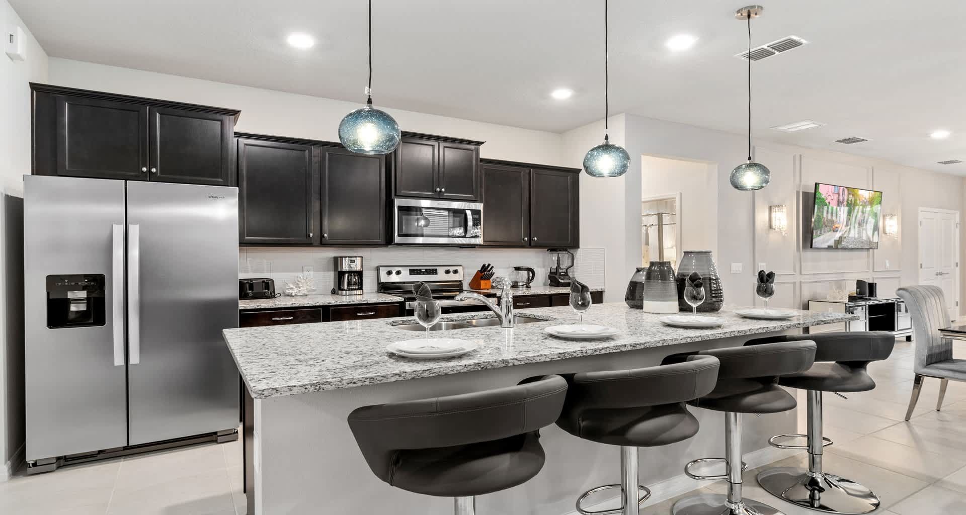 Modern kitchen with sleek black cabinets, granite island, and stylish lighting!
