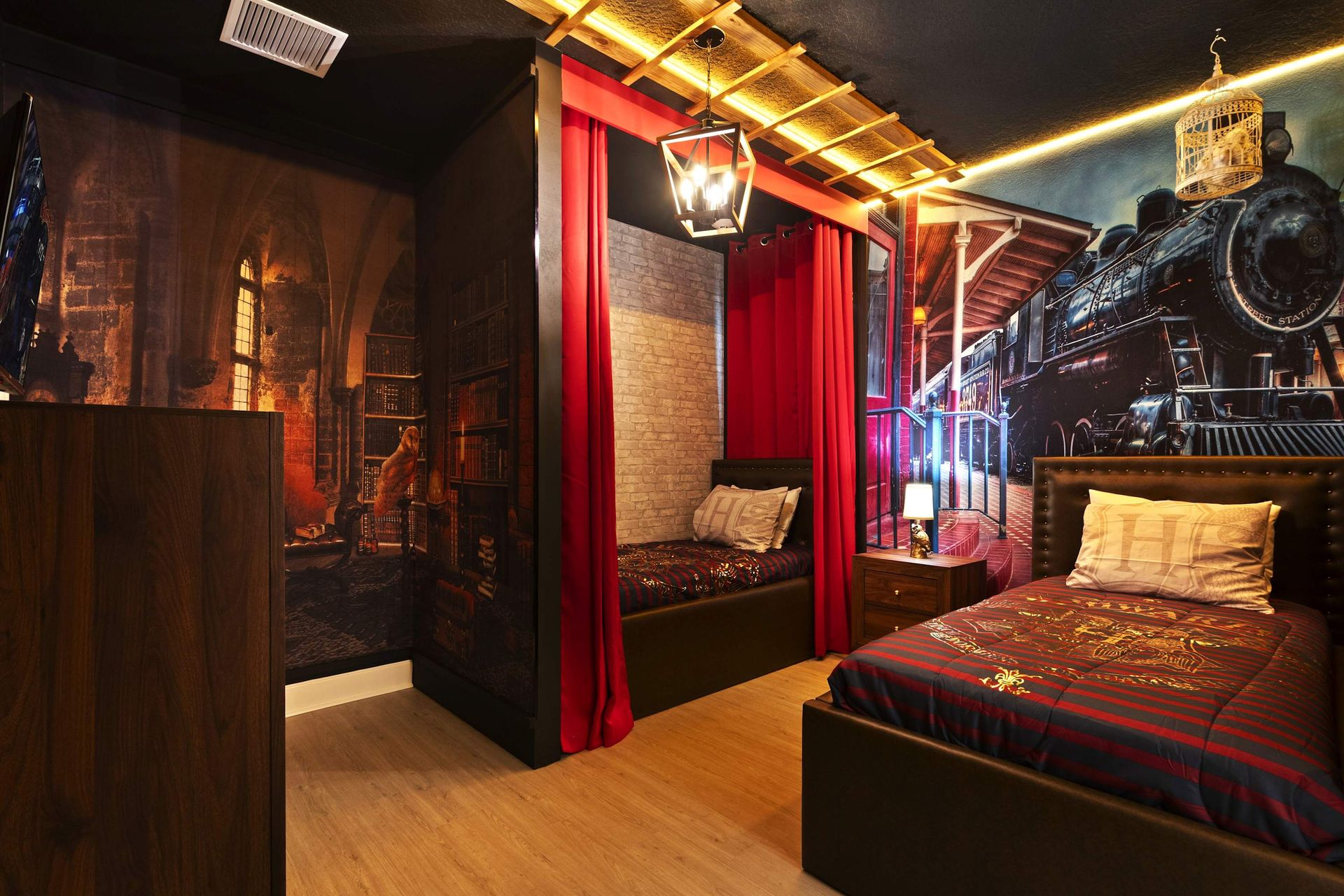 All aboard! Wizard theme with train mural and curtained cabin bunks. 