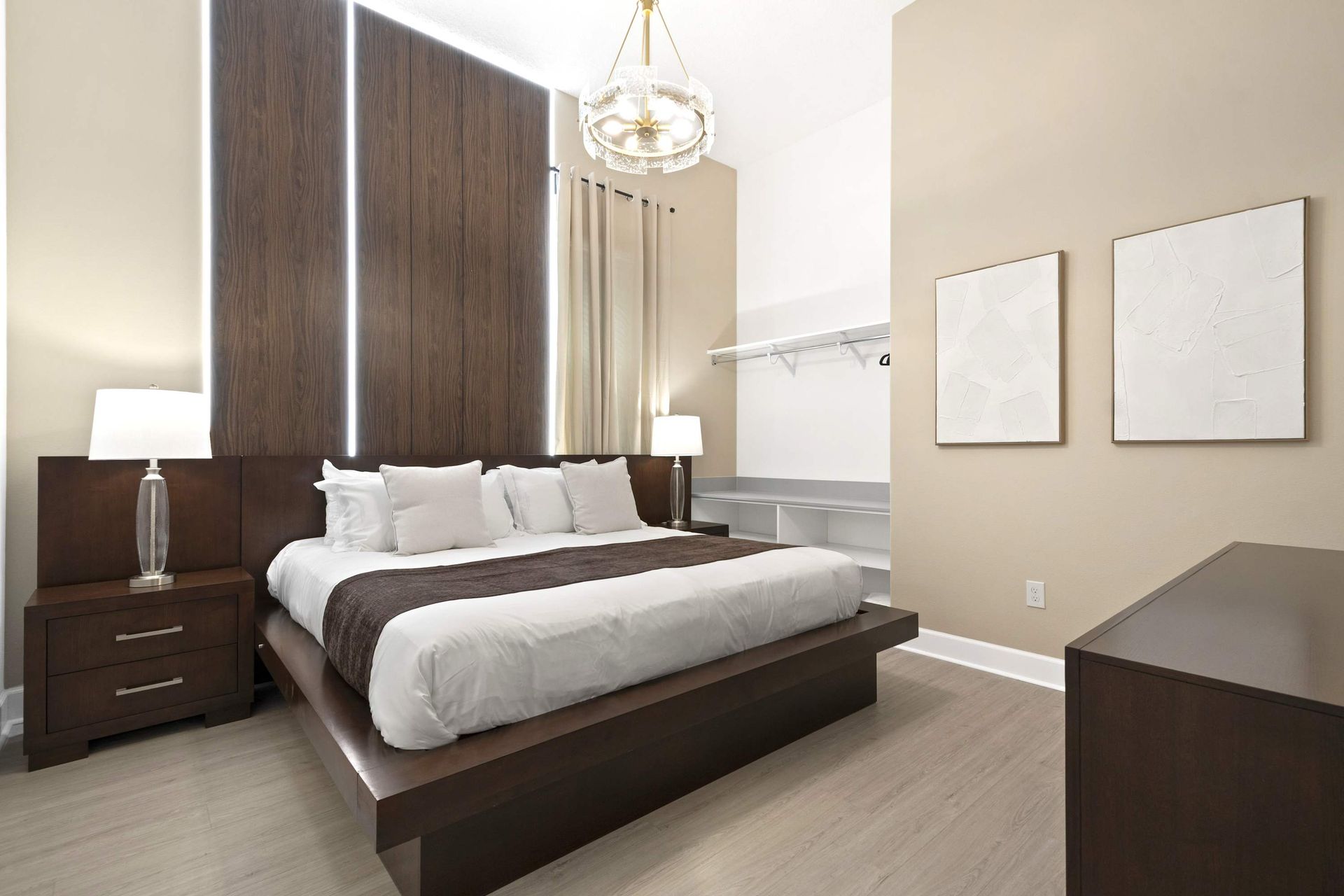 Sleek platform King bed, wood accent wall, and stunning lighting.