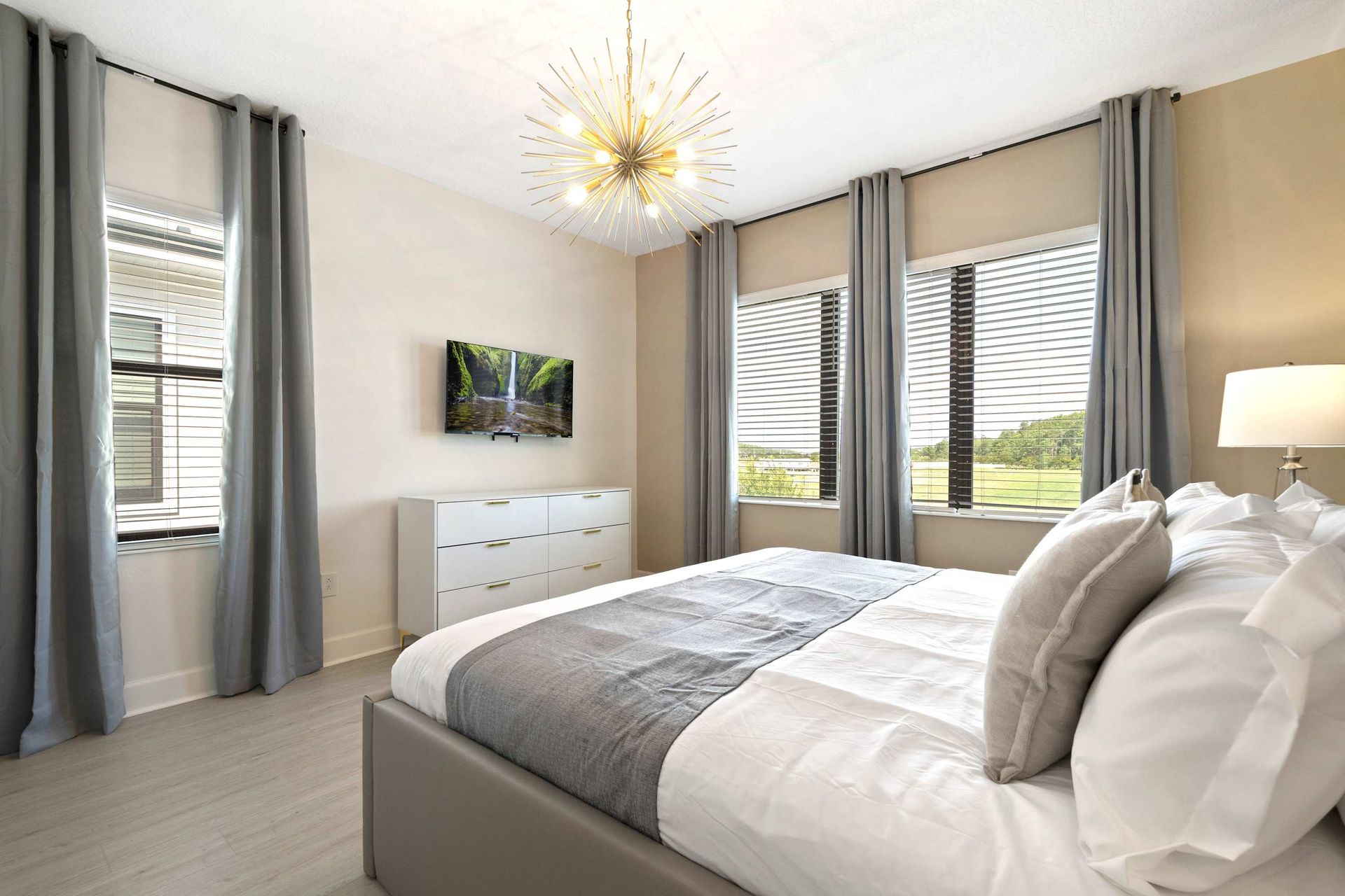 Plush King bed, bright windows, and a TV for ultimate relaxation.