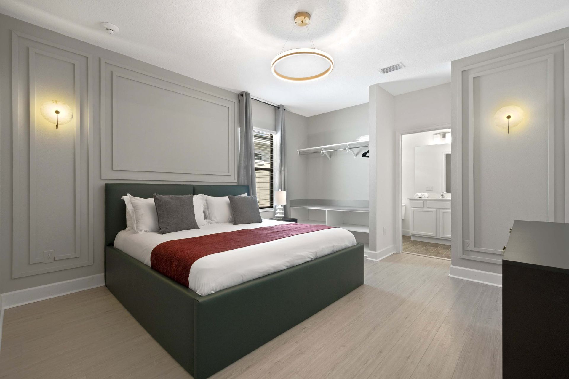 Chic panel molding, elegant light, and plush bed define this suite.