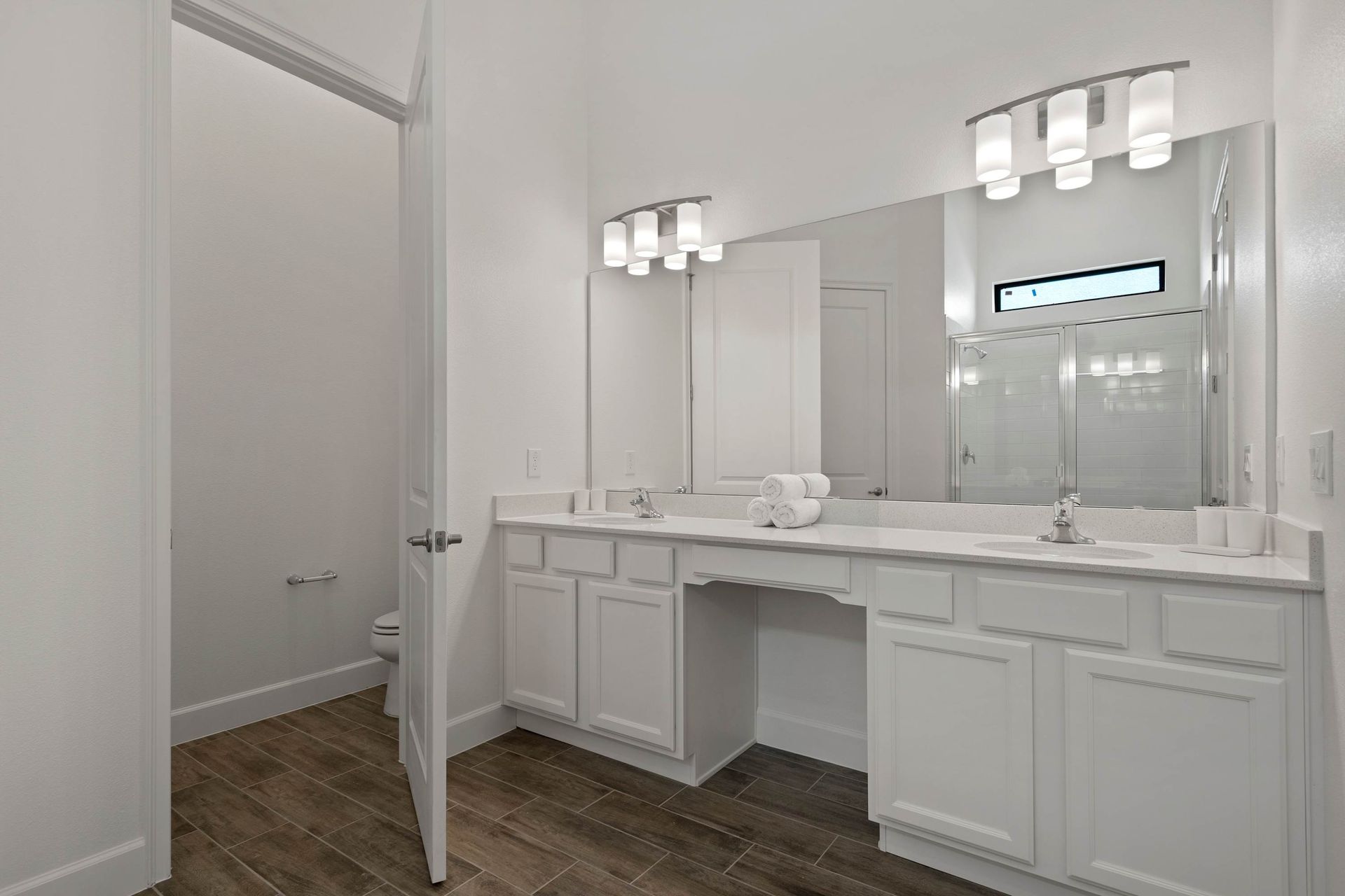 Spacious master bath with dual vanity, makeup counter, and large mirrors.