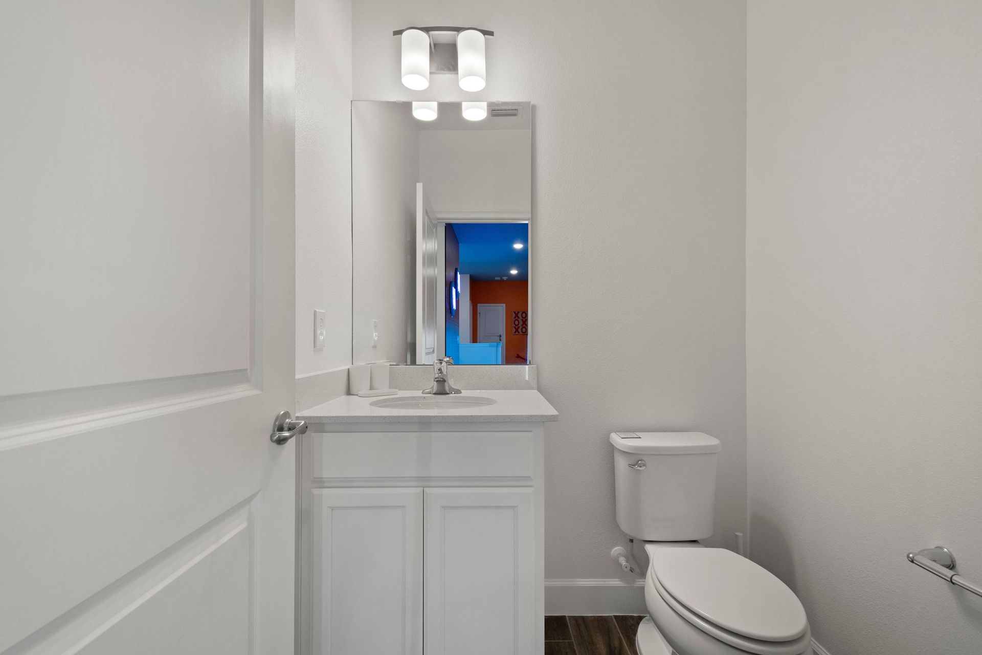 Clean and bright powder room with modern white vanity. 