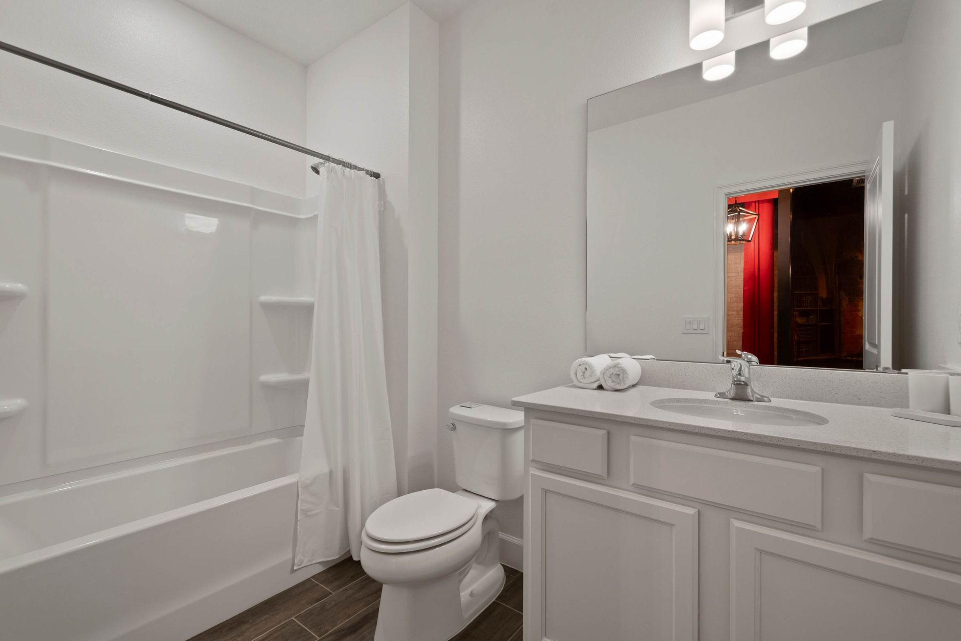 Modern white bathroom with ample mirror space and simple design.