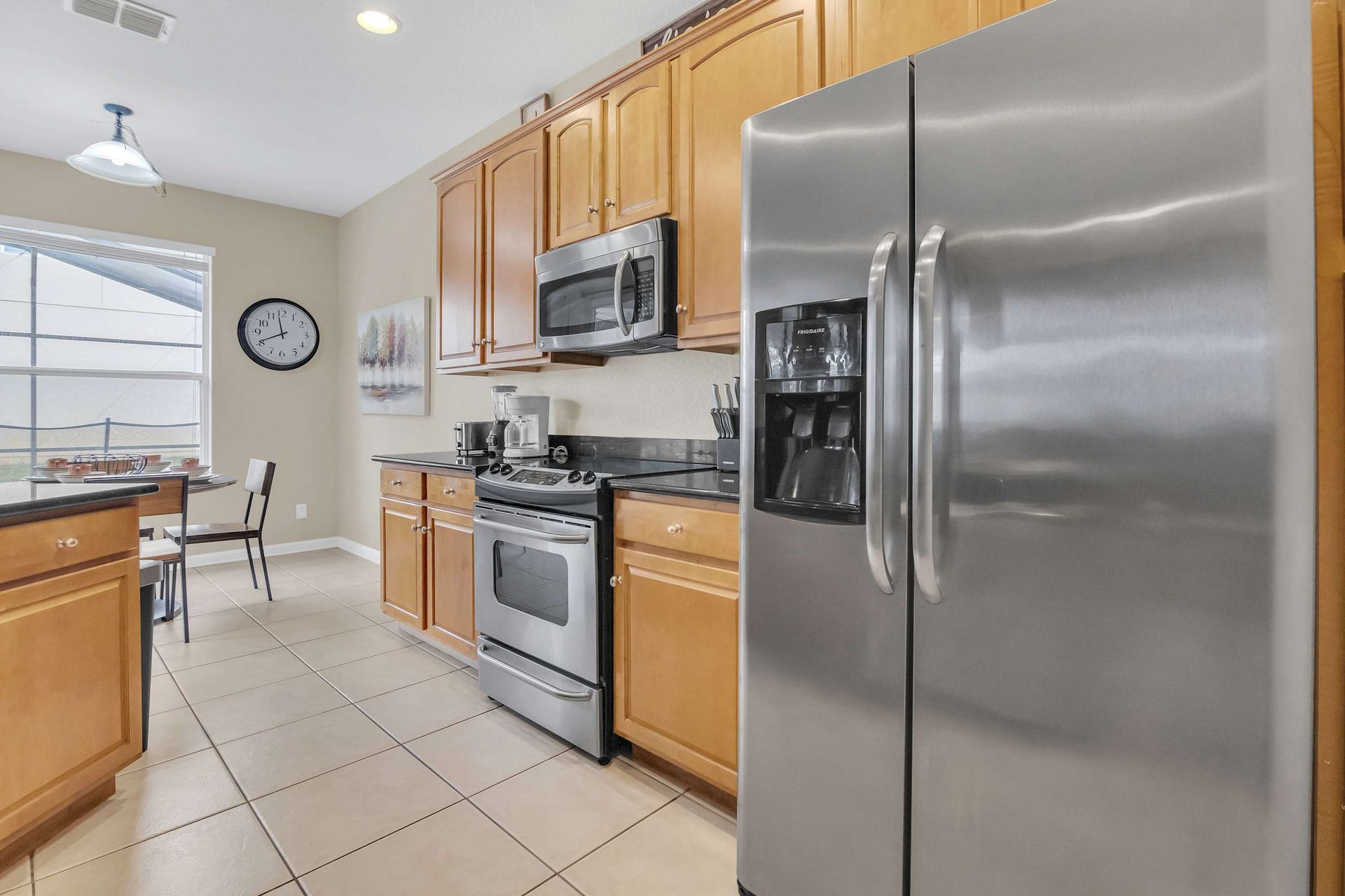 Spacious kitchen with wood cabinets, dark counters, and breakfast nook.