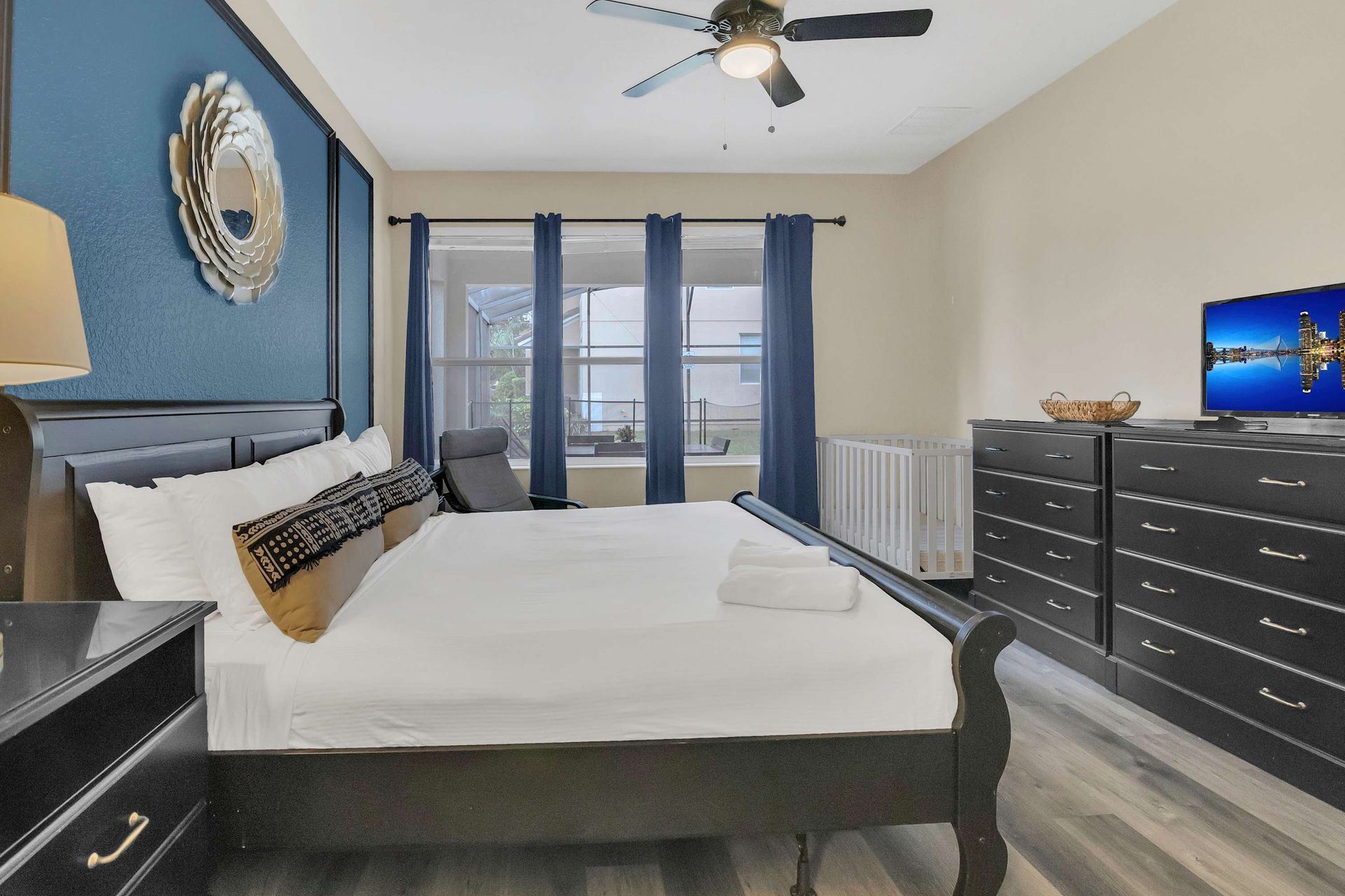 Dramatic navy accent wall and sleigh bed in a cozy, stylish suite.