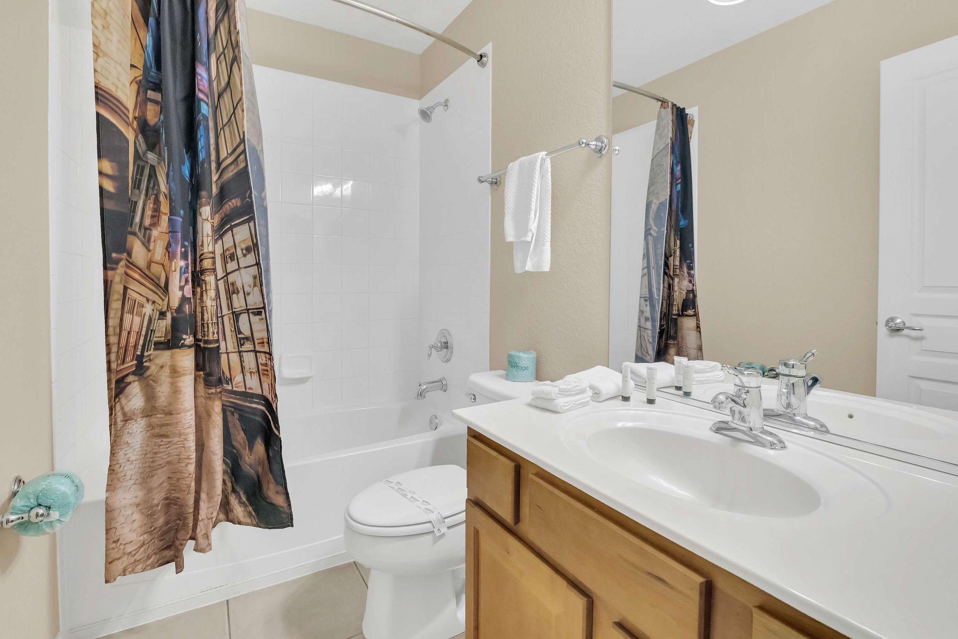 Full bath with tub and a fun, unique city-themed shower curtain.